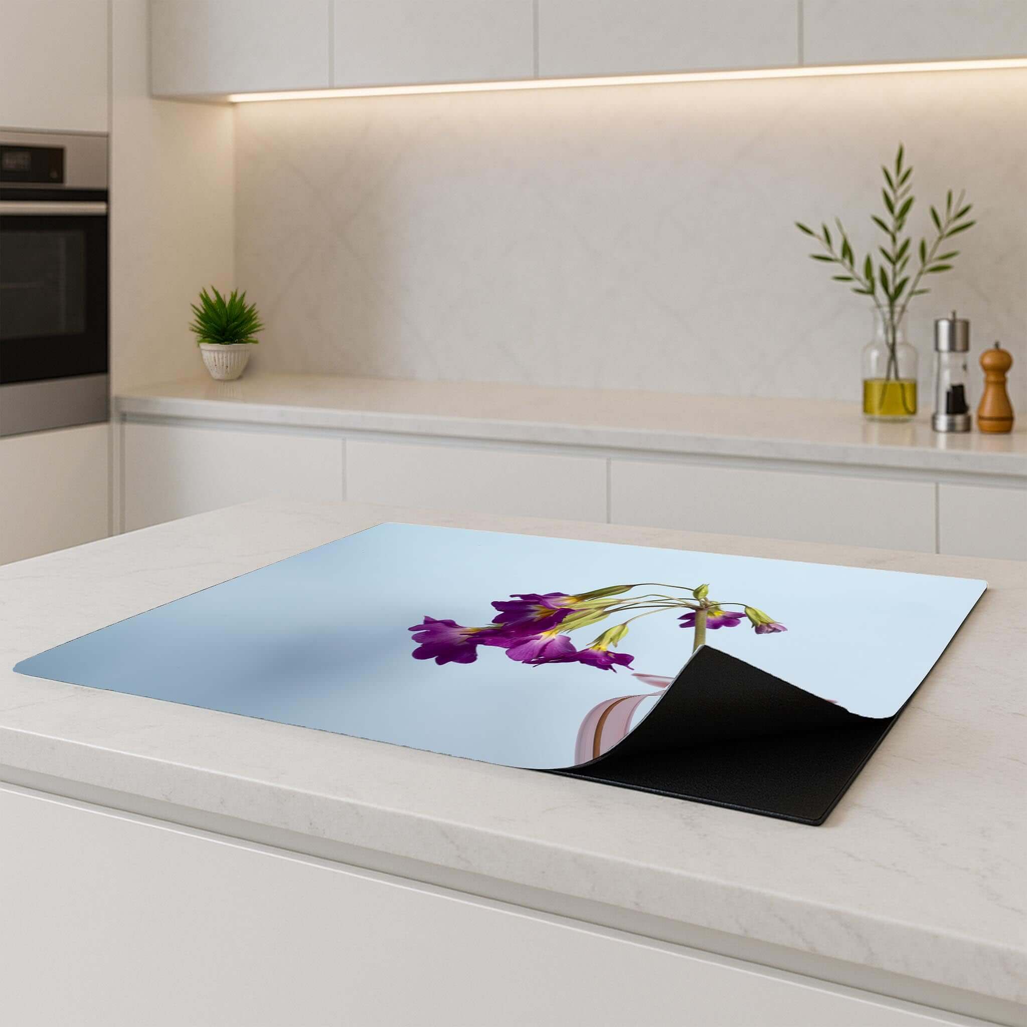 Delicate Drop Inductie Beschermer met bloemenprint op een moderne keukentafel.
