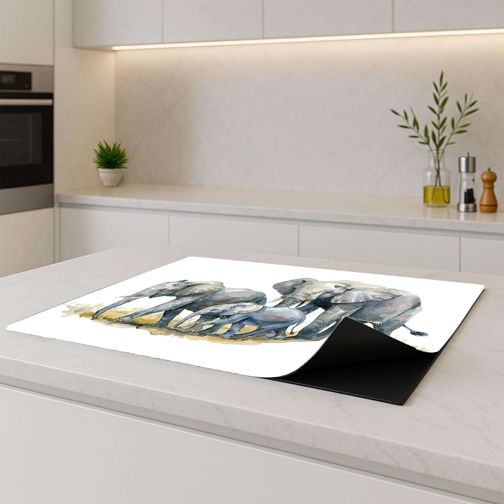 Inductiebeschermer met olifanten aquarelprint op modern keukeneiland, deels opgerold.