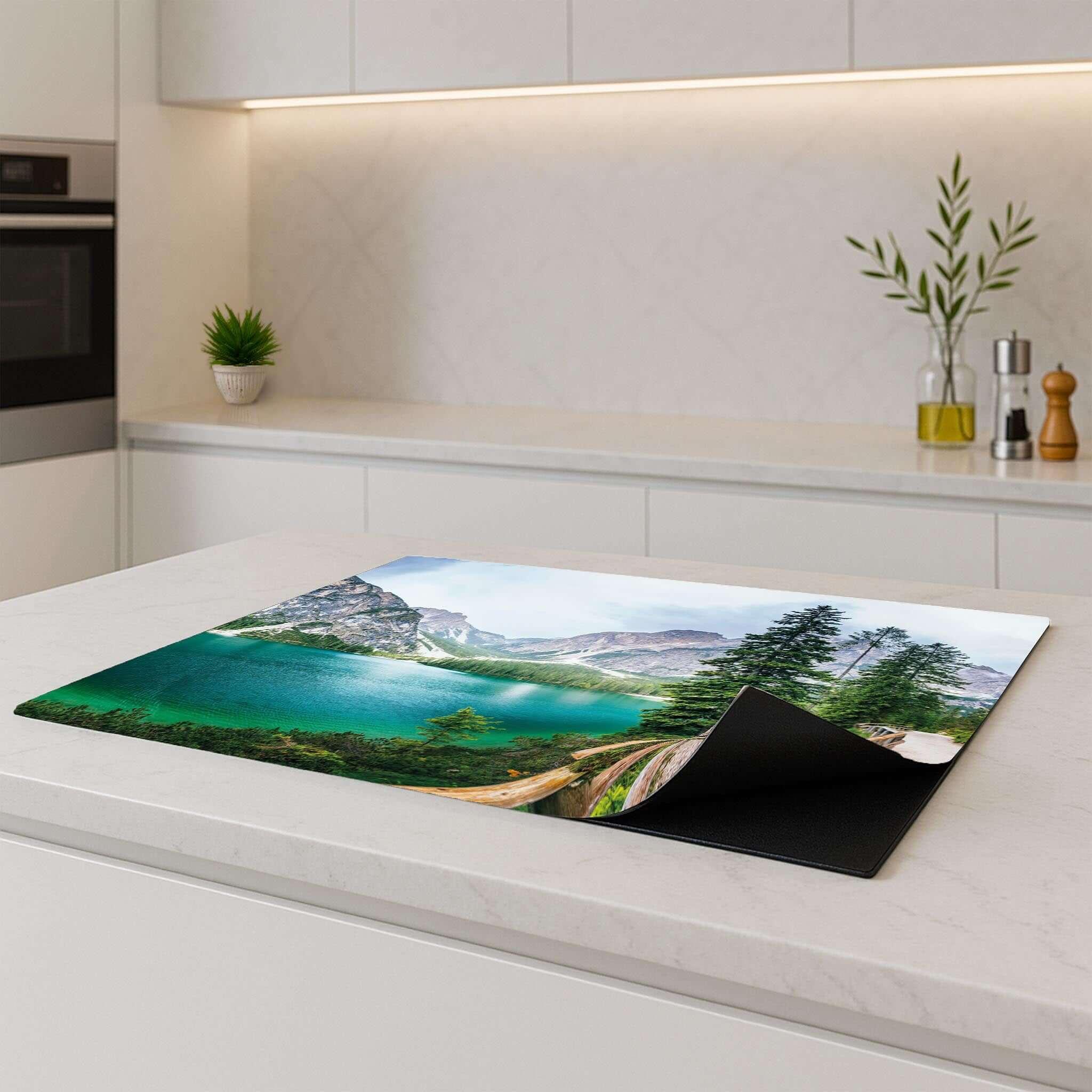 Inductie beschermer met natuurscène op een modern keukenblad.