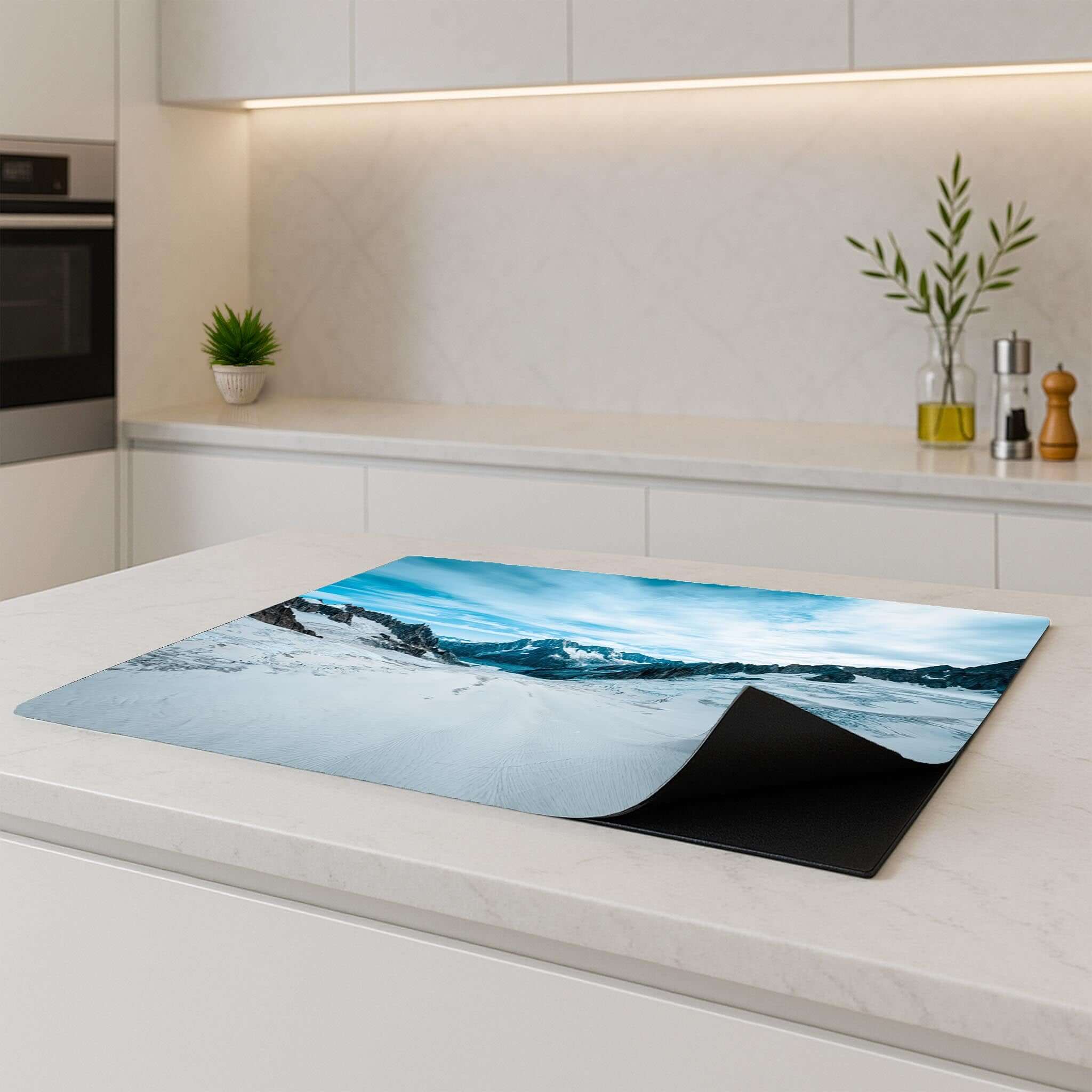Frozen Peaks inductiebeschermer liggend op een kookplaat in een strakke keuken