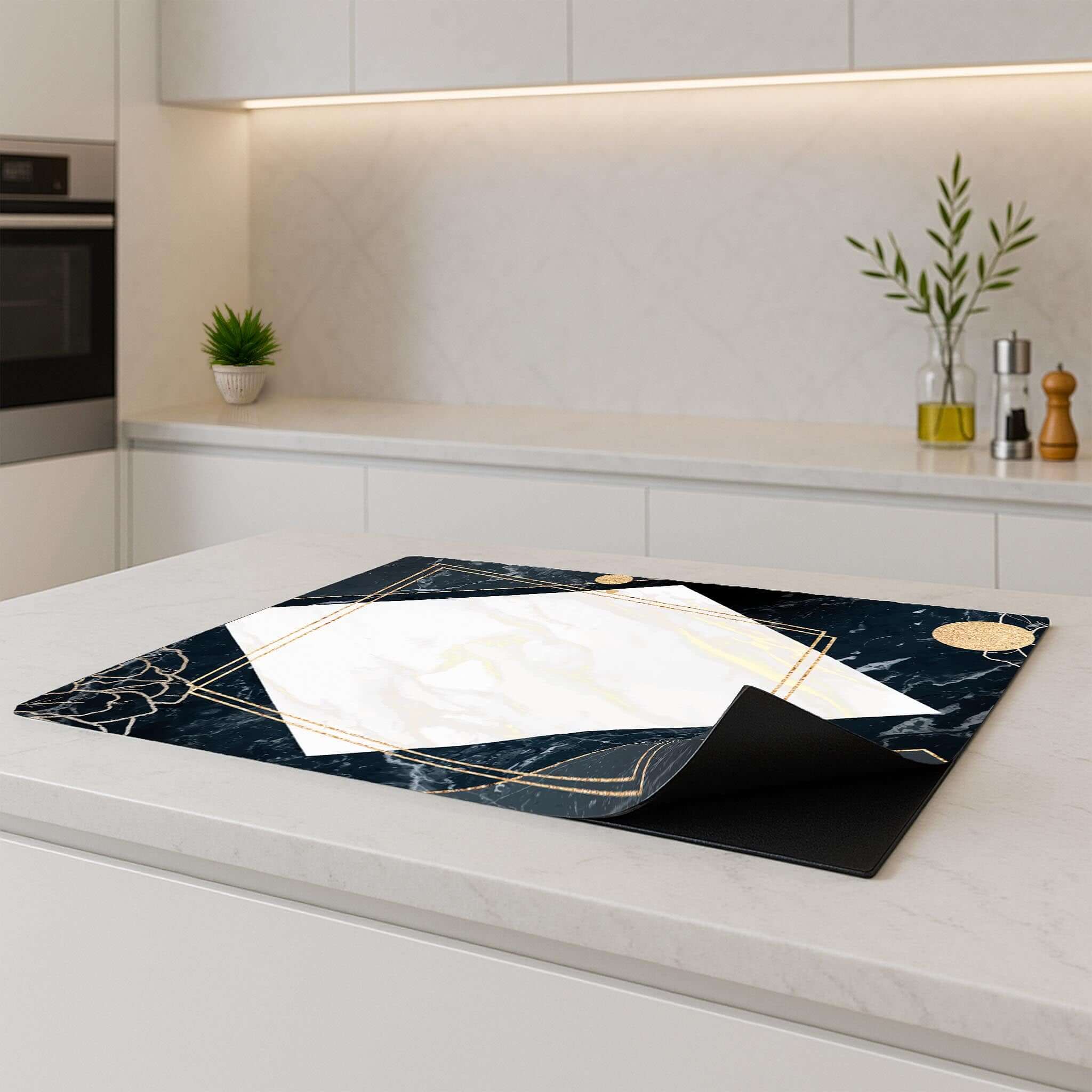 Glamour Marble inductie beschermer op een modern keukenblad, met luxe marmer en goud details.