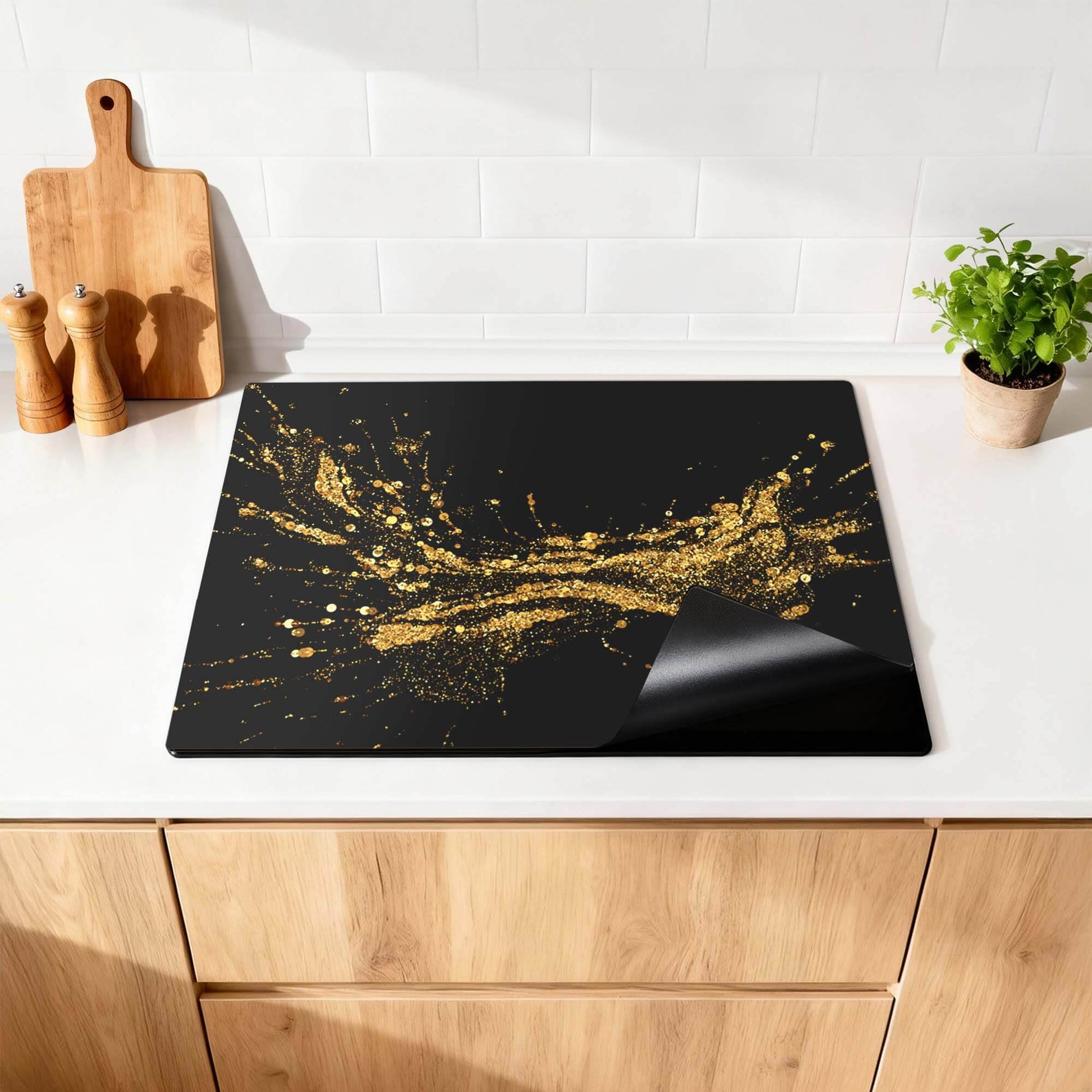 Golden Splash - Inductie Beschermer op een stijlvolle keukenwerkblad, gecombineerd met luxe en praktische bescherming.