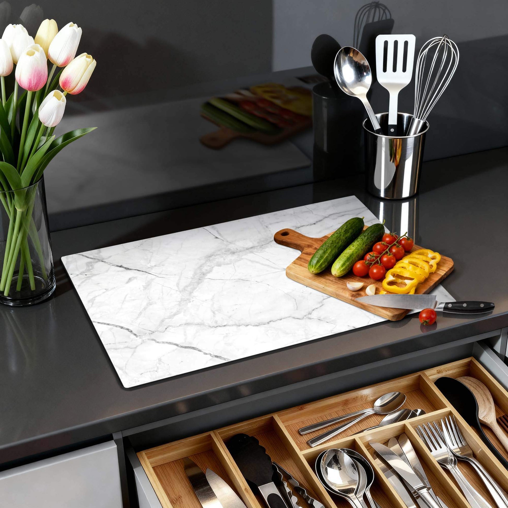 Carrara Light - Inductie Beschermer op een keukenblad met groenten en bloemen.