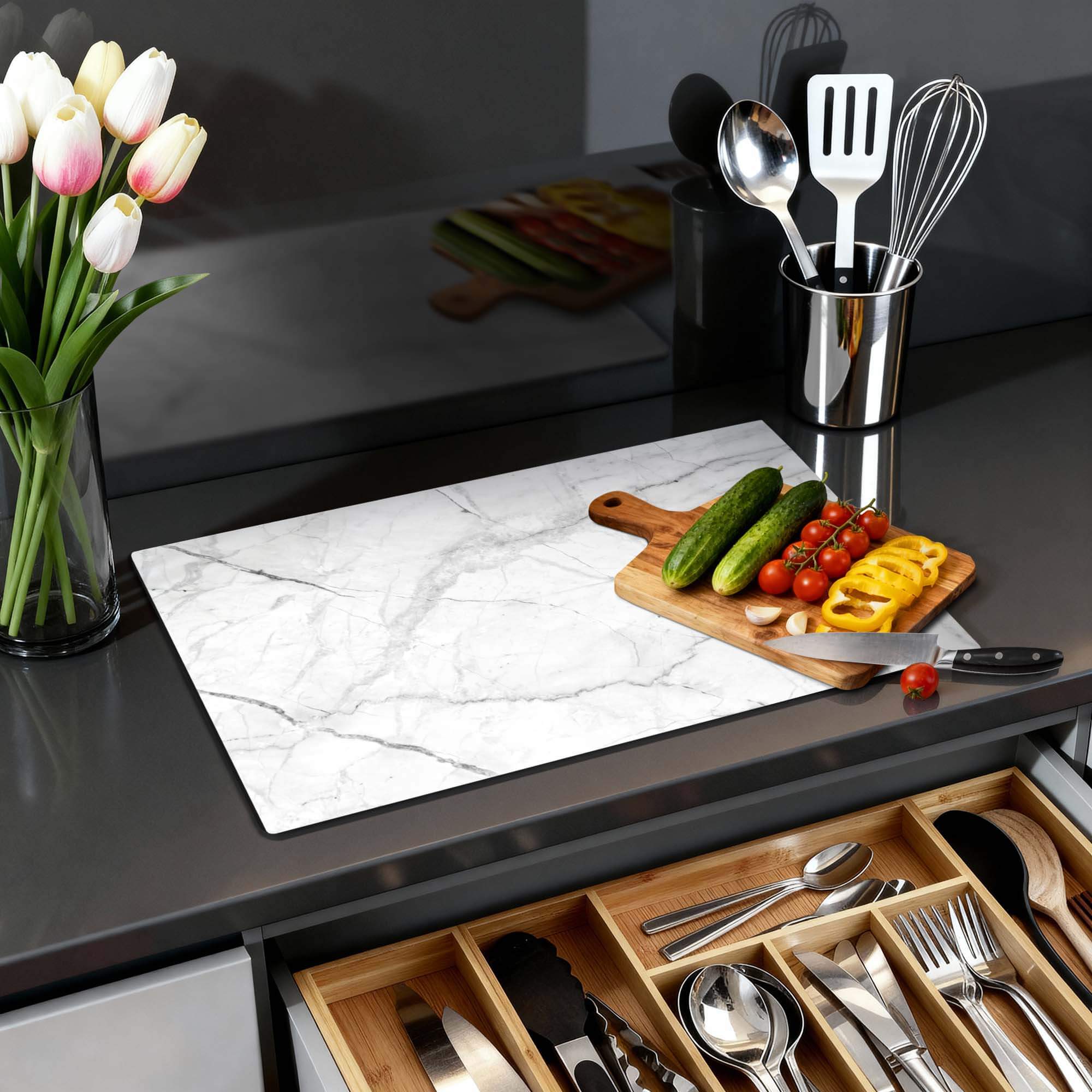 Carrara Light - Inductie Beschermer op een keukenblad met groenten en bloemen.