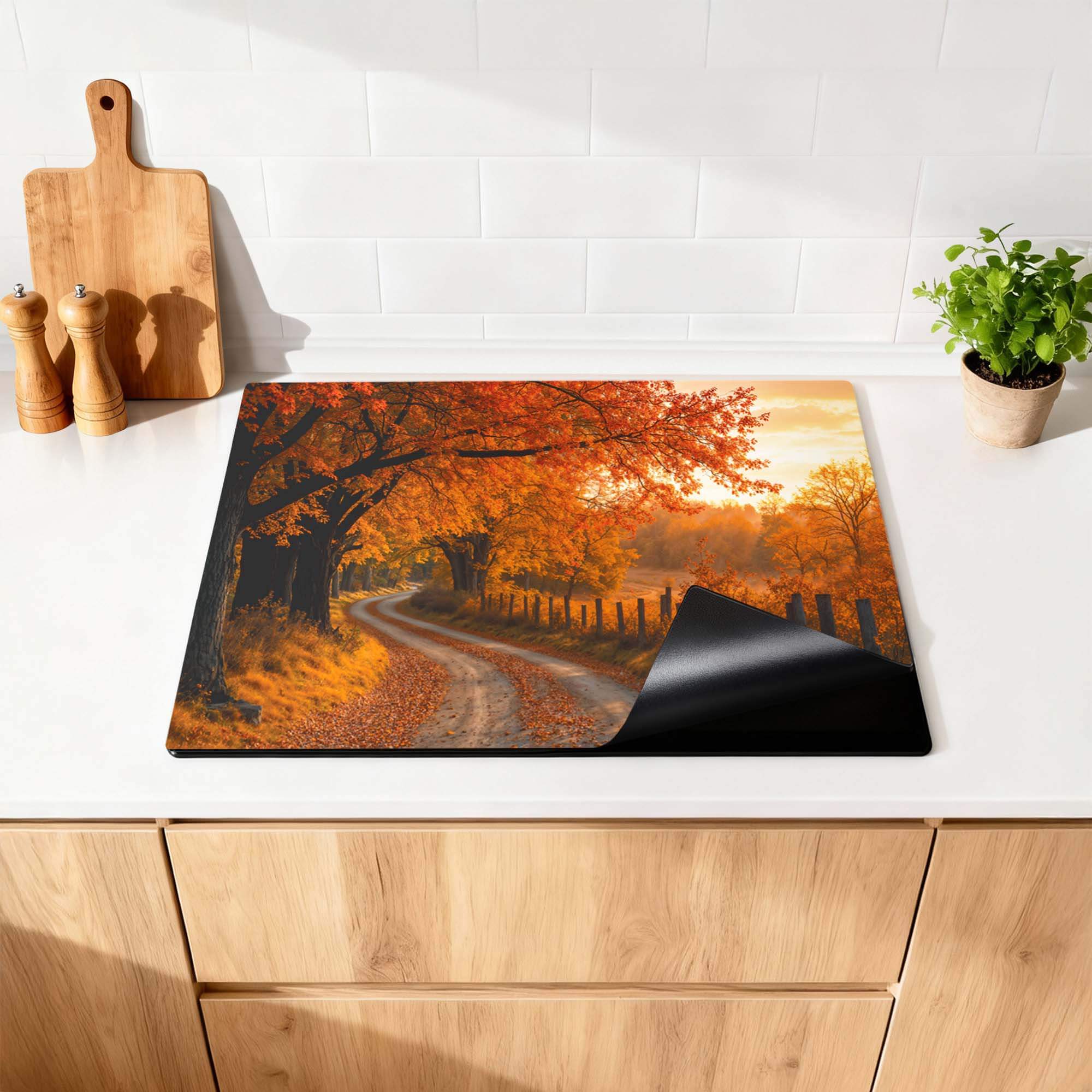 Golden Autumn – Inductie Beschermer op een keukentafel met warme herfstkleuren van feloranje bladeren.