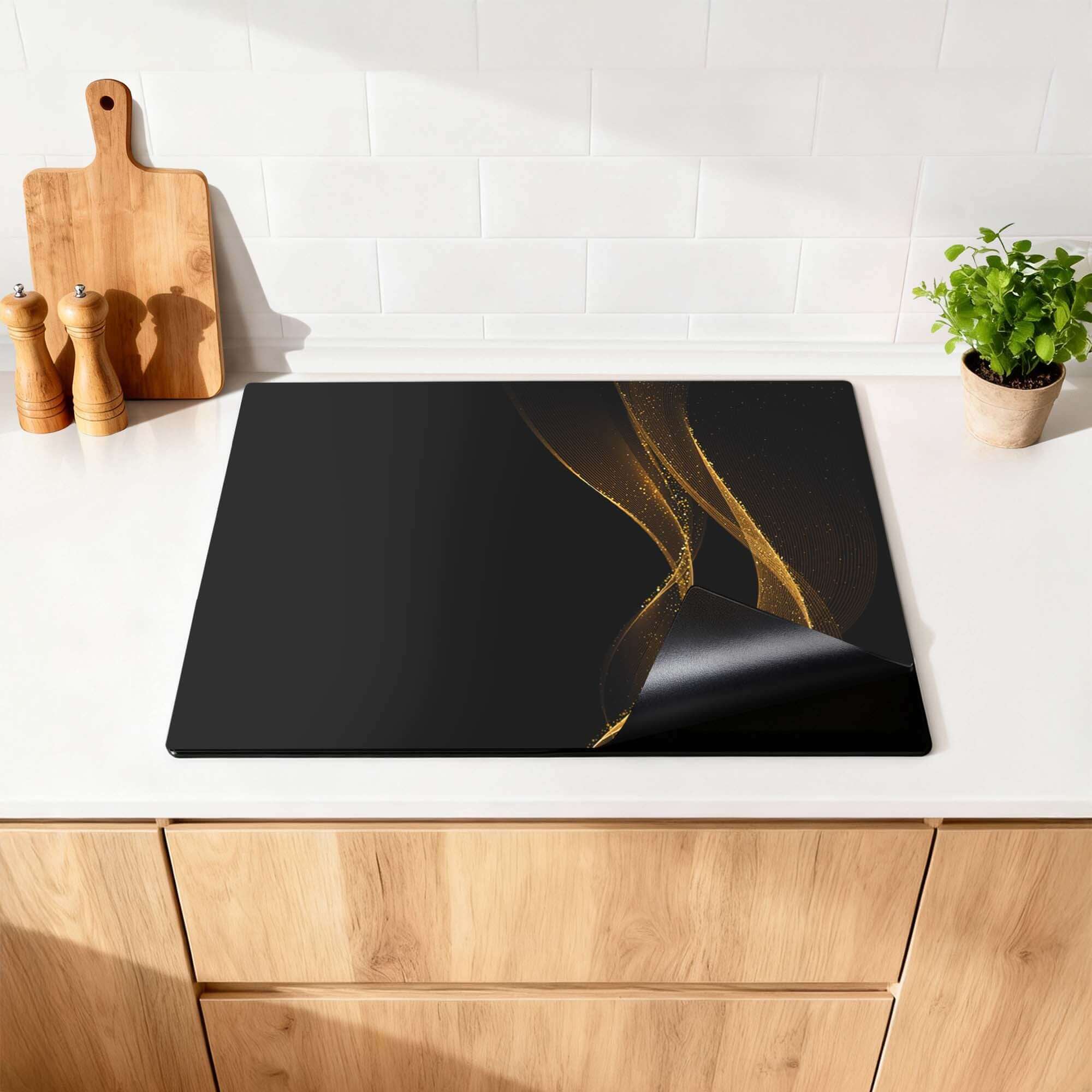 Golden Flow – Inductie Beschermer op een keukenblad met gouden print op zwart.