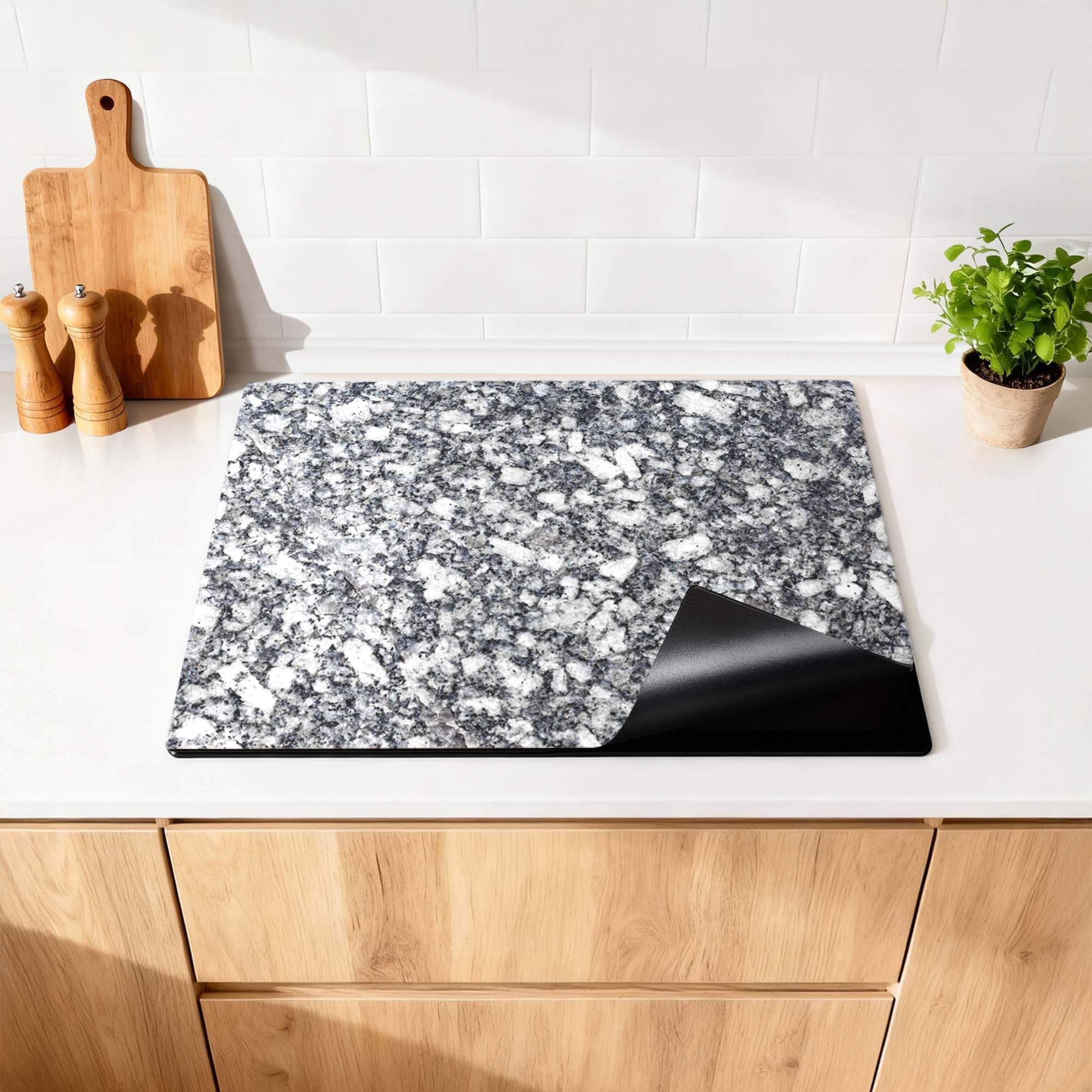 Midnight Granite - Inductie Beschermer op een moderne keukenaanrecht, biedt luxe en bescherming voor je kookplaat.