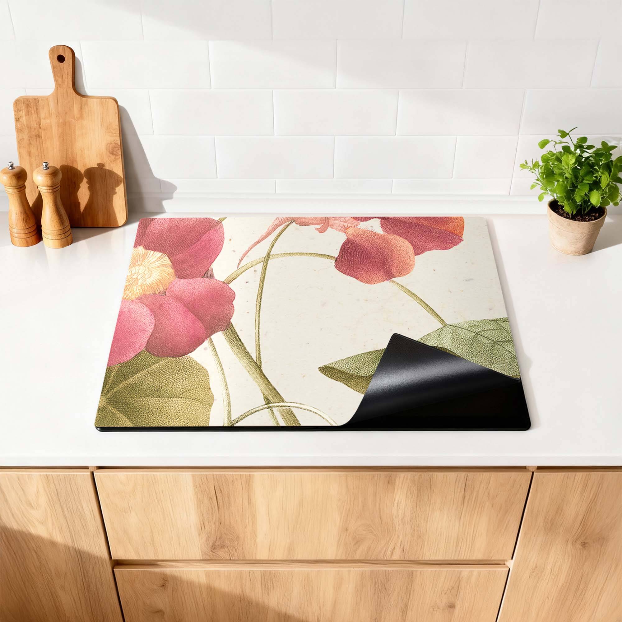 Petal Whisper – Inductie Beschermer op een keukenblad met bloemenprint en zwarte achterkant.