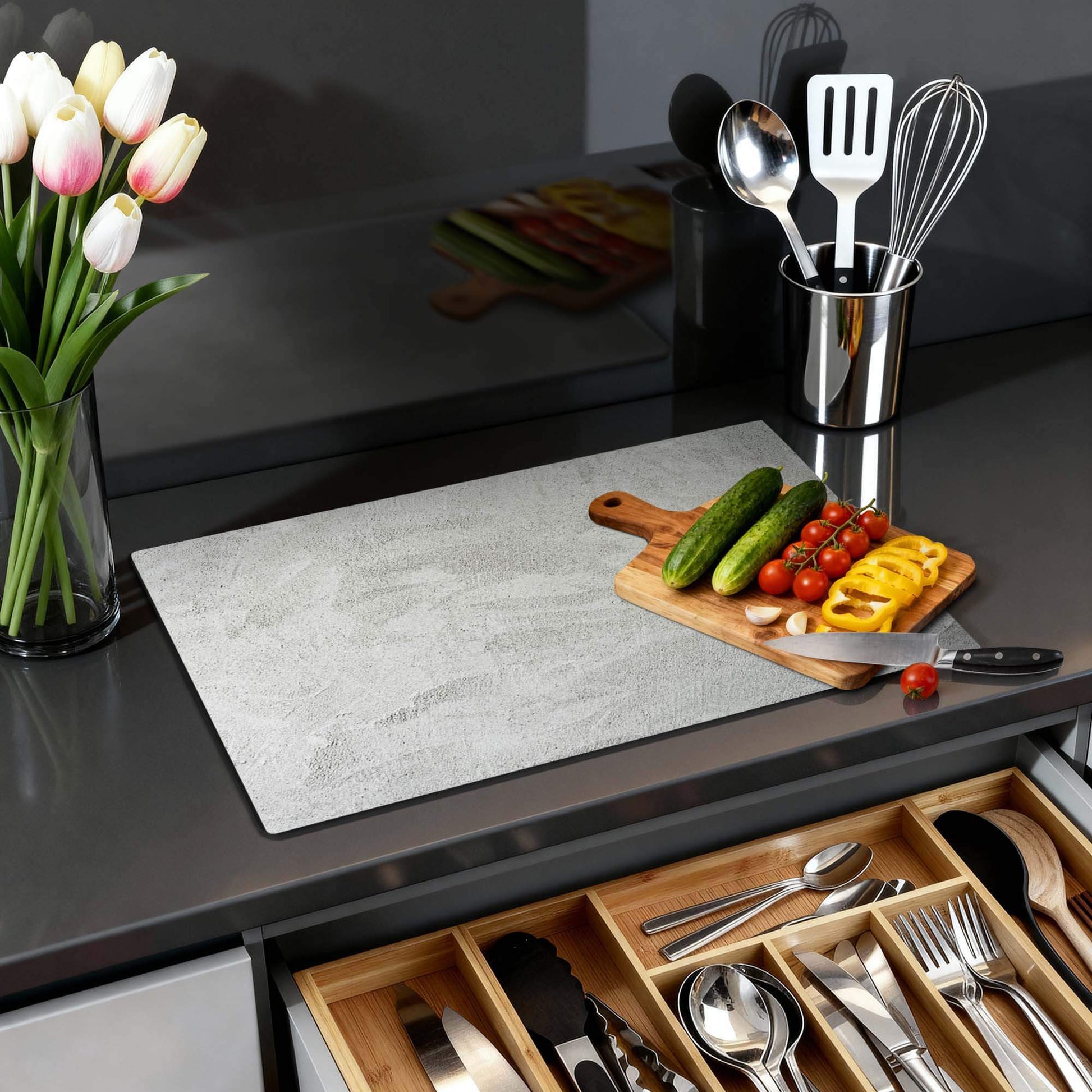 Soft Concrete Finish – Inductie Beschermer op een moderne keuken met groenten en keukenaccessoires.