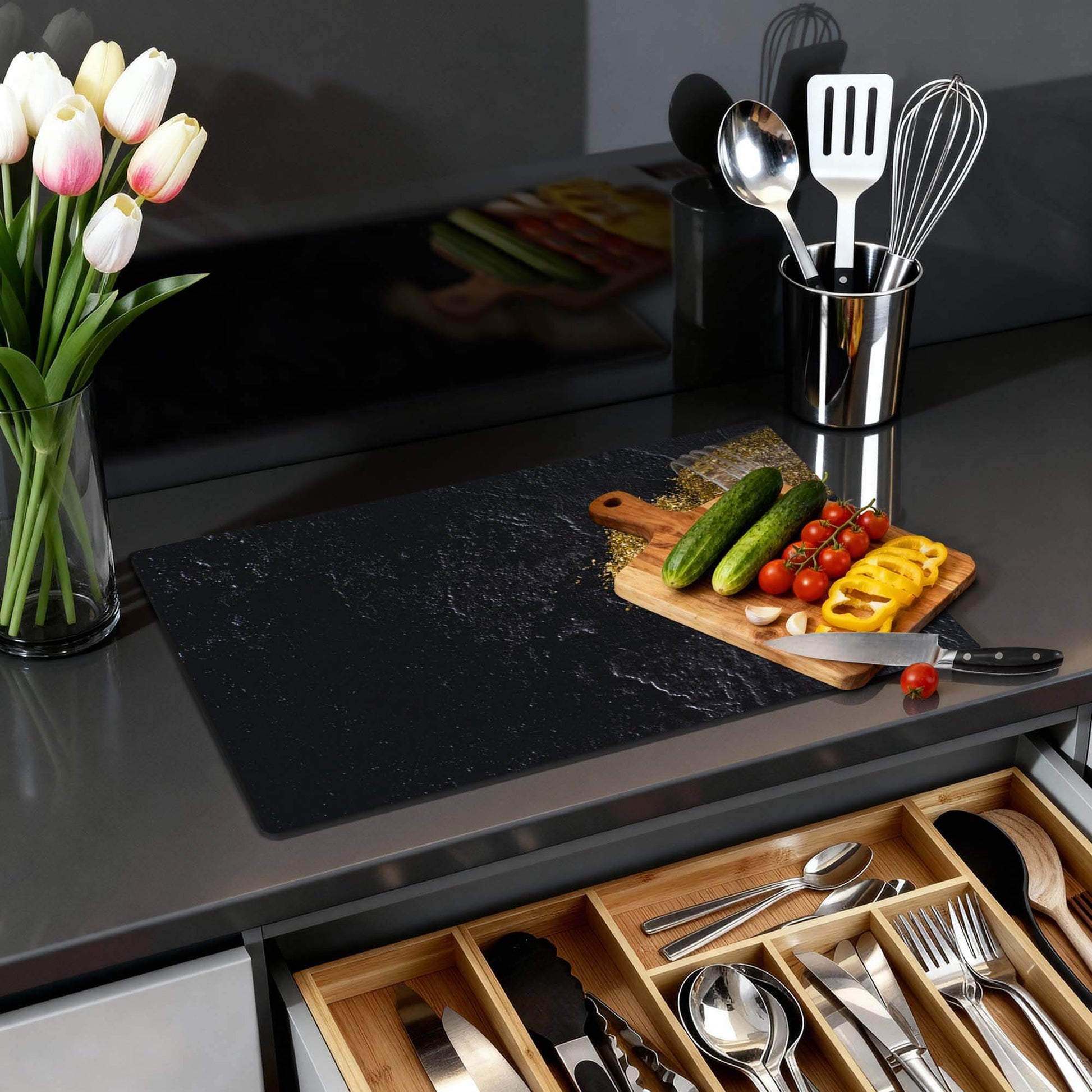 Spilled Gold - Inductie Beschermer in moderne keuken met groente en keukenaccessoires op zwart werkblad.