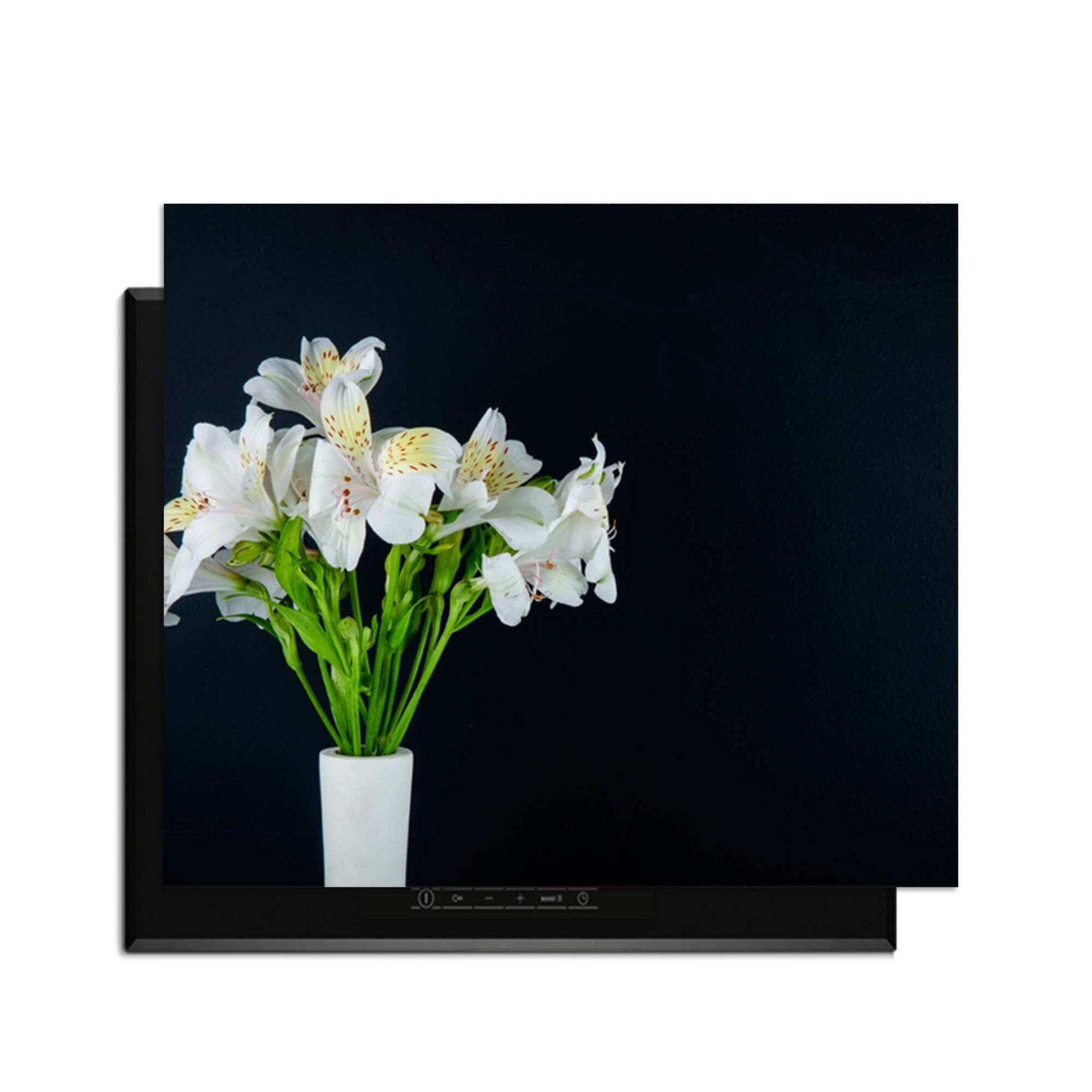 White Whisper - Inductie Beschermer met witte bloemen op een inductiekookplaat met zwart achtergronden.