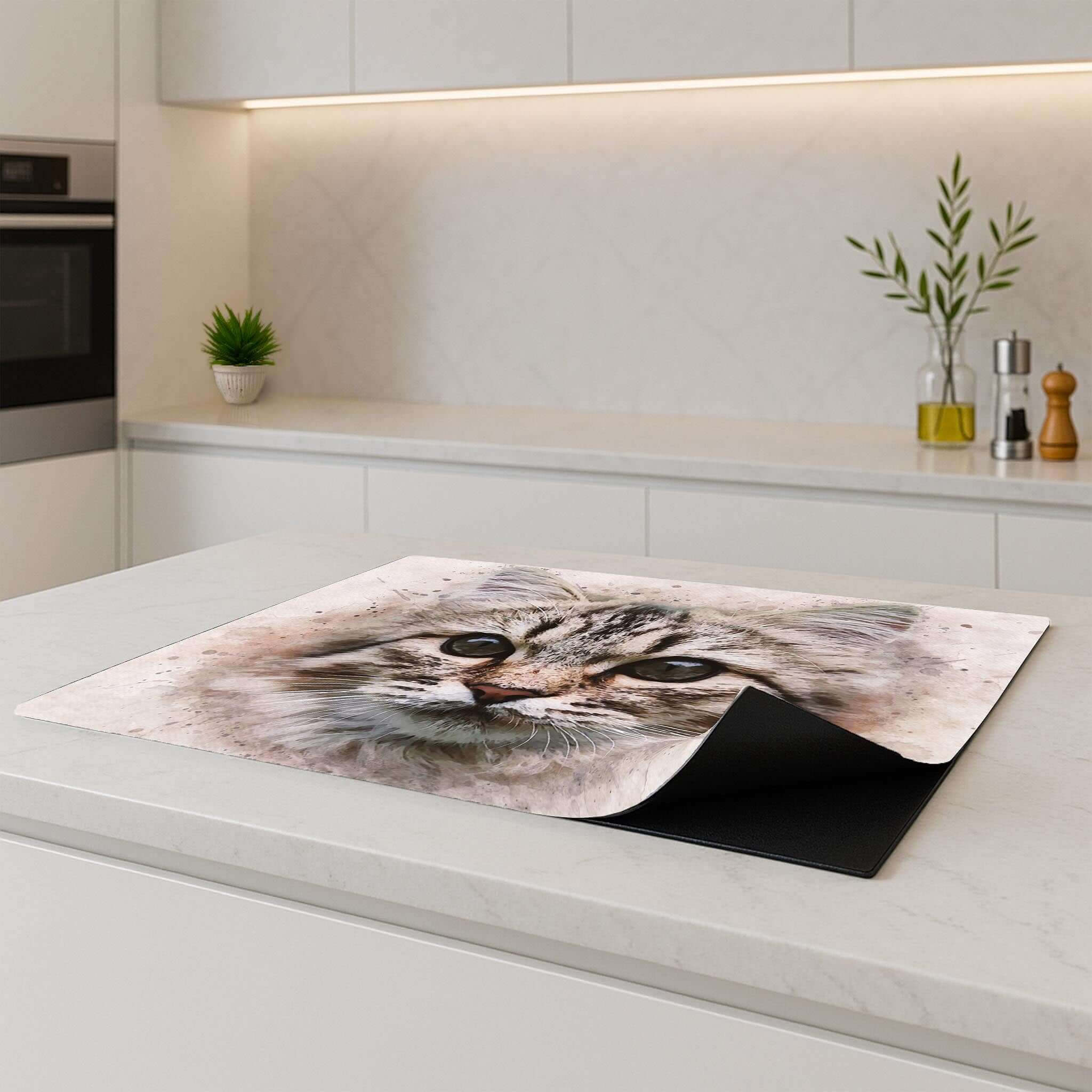 Inductiebeschermer met kattenportret op een inductiekookplaat in moderne keuken