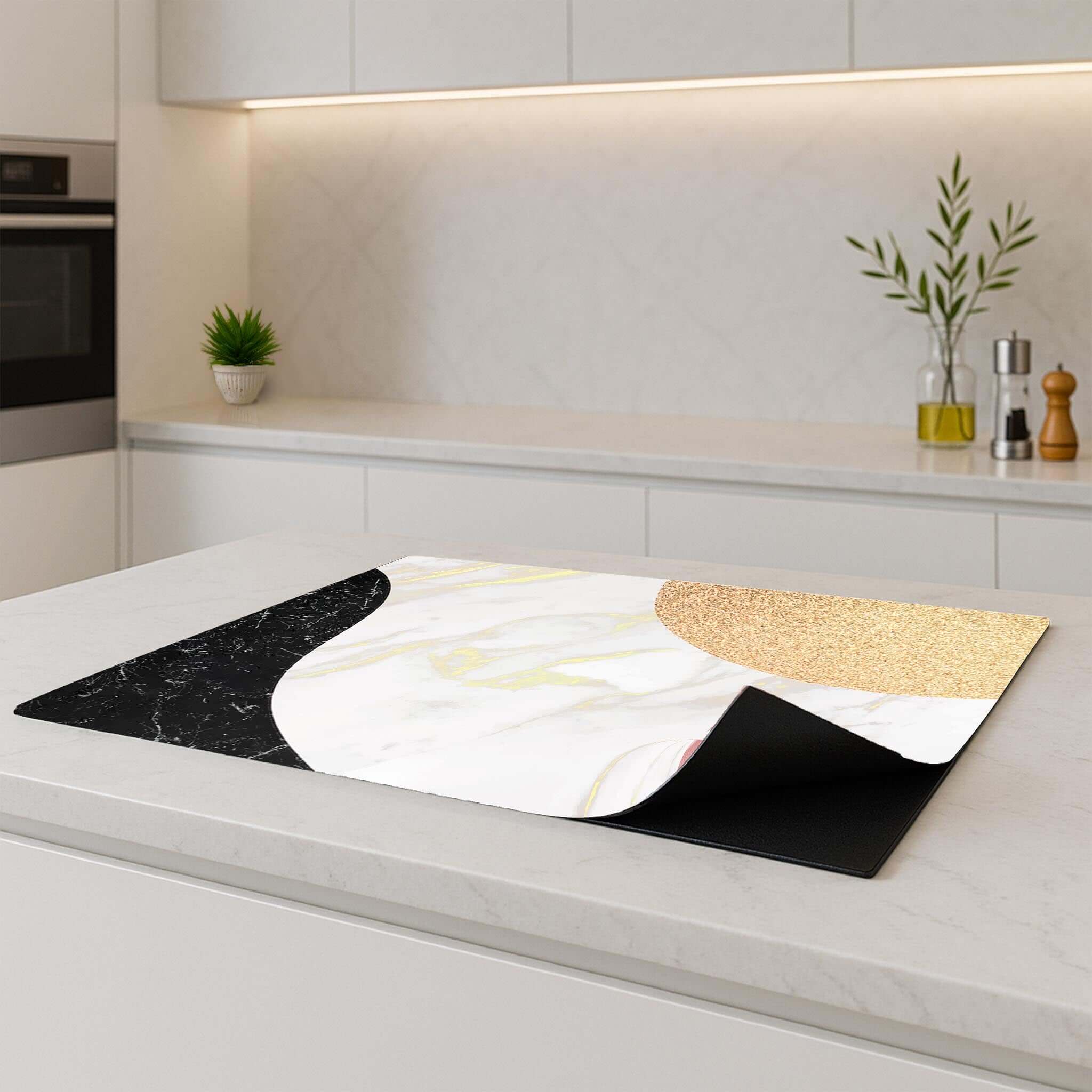 Marble Chic inductie beschermer op een modern keukenblad, met stijlvolle marmer en goud/roze details.