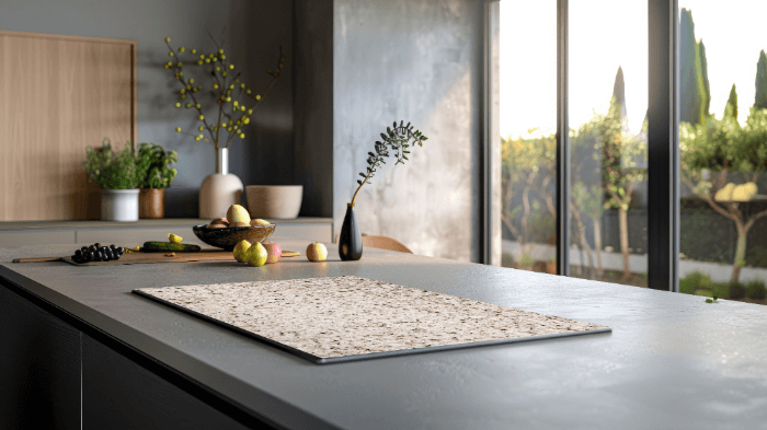 Stijlvolle inductie beschermer met almond graniet look op een modern keukeneiland met natuurlijke lichtinval