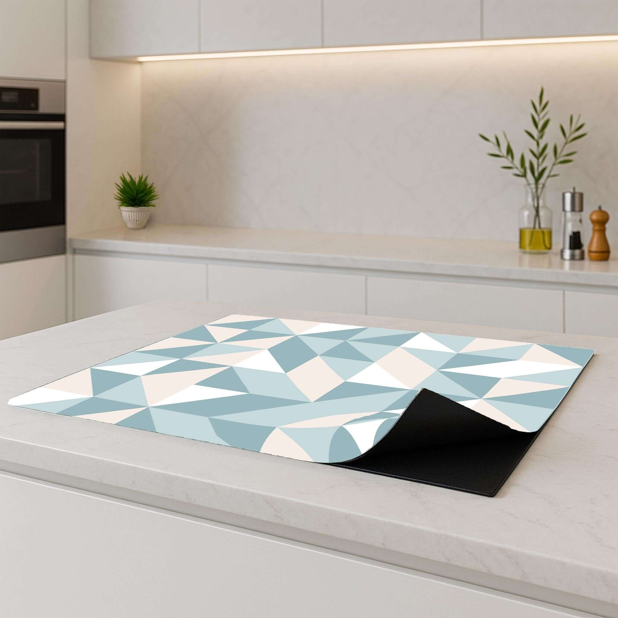 Zijkantweergave van de Pastel Triangles inductie beschermer op een modern keukenblad
