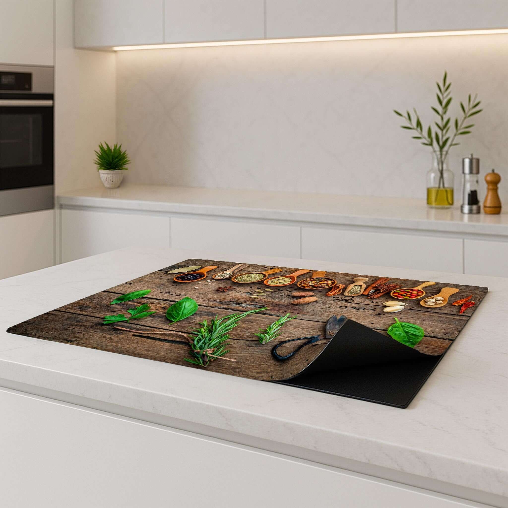Inductie Beschermer van Roots & Recipes met kruiden op een houten aanrecht in een moderne keuken.