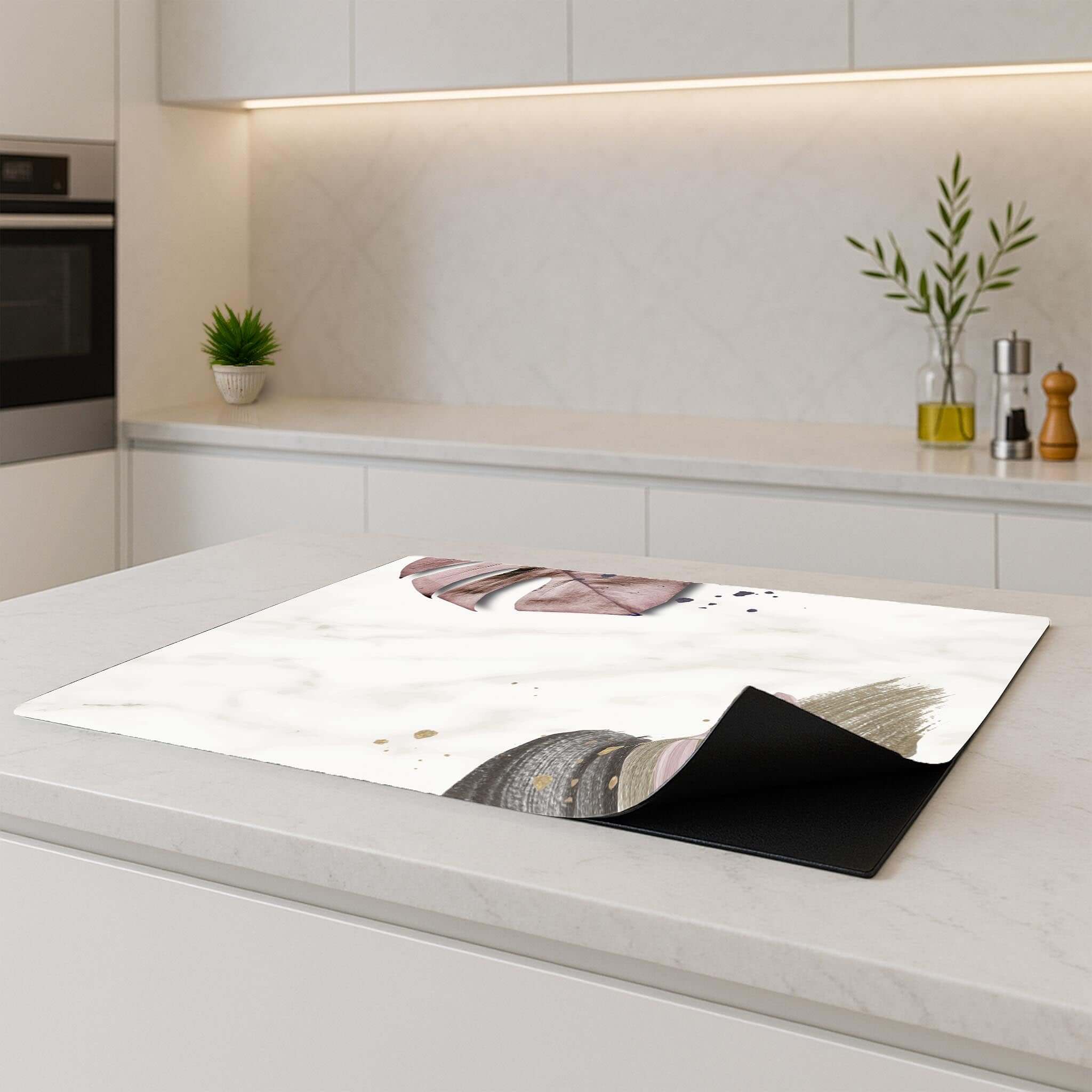 Inductie beschermer Soft Blush met blush en taupe tinten, geplaatst op een wit keukenblad