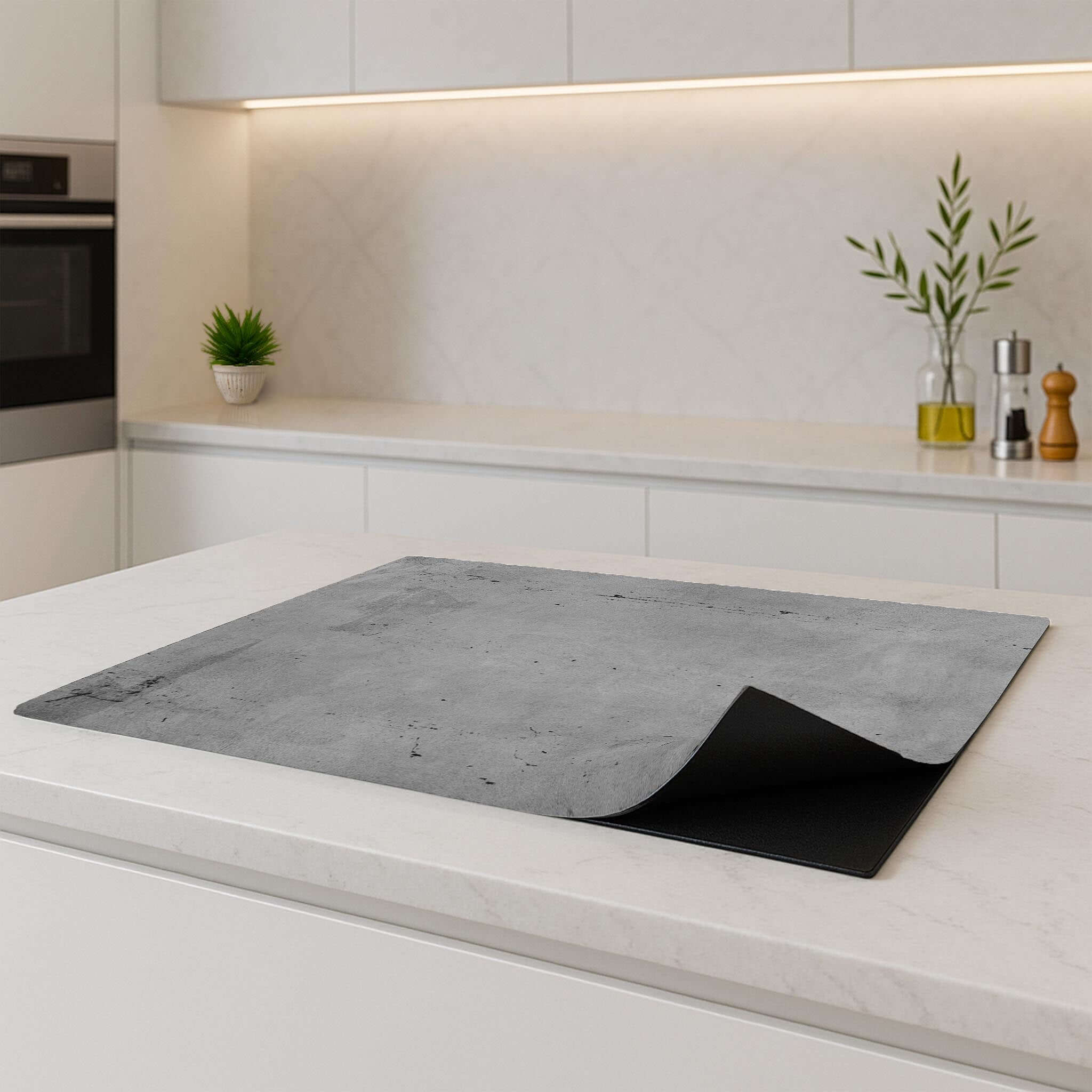 Urban Slate inductiebeschermer op een wit keukenblad, industrieel betonpatroon.