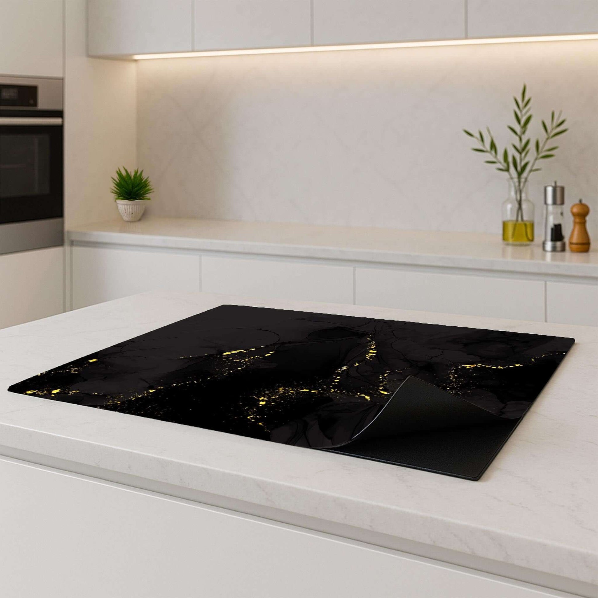Black Marble Gold inductie beschermer – zwarte beschermer met gouden aders, opgerolde hoek in moderne keuken