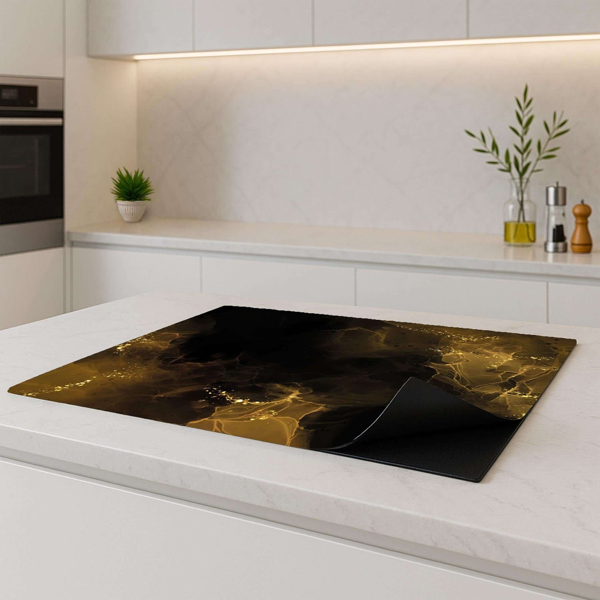 Golden Smoke inductie beschermer – luxe zwart-goud ontwerp met opgerolde hoek op een licht keukenblad