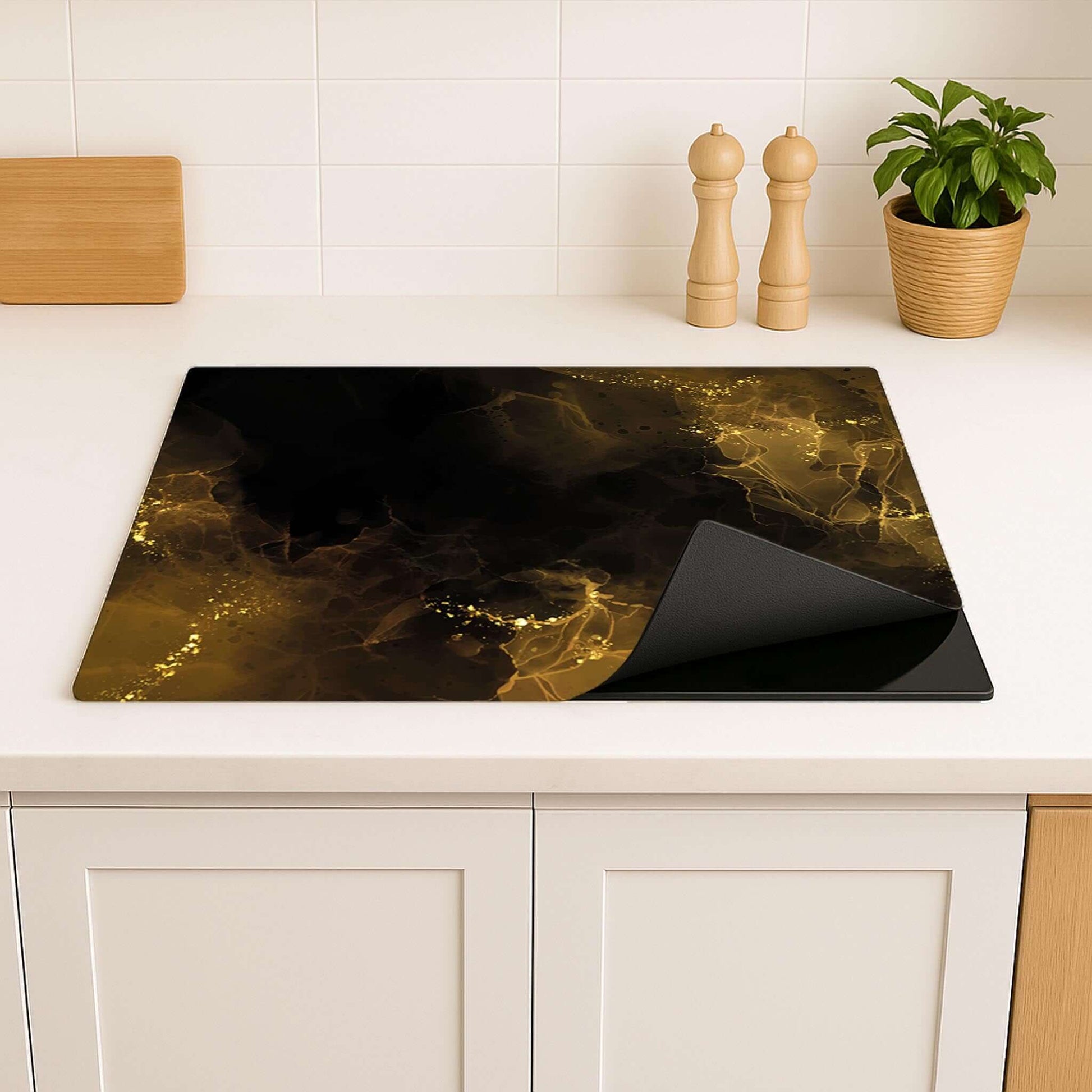 Golden Smoke inductie beschermer – zwart met gouden waas, antislip en oprolbaar, op aanrechtblad in moderne keuken