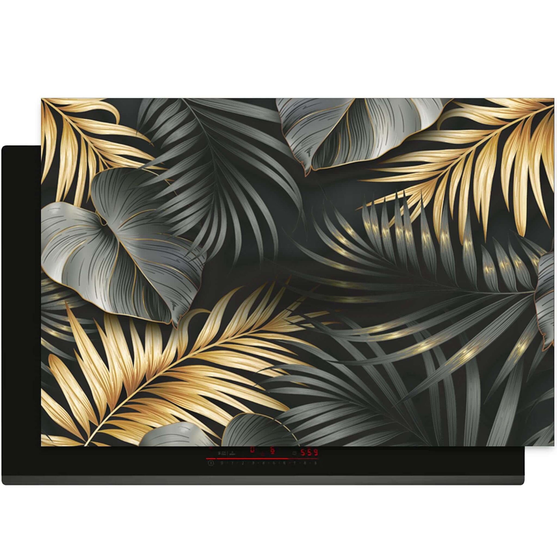 Golden Palms inductie beschermer – zwart met gouden en zilvergrijze palmblaadjes op inductiekookplaat