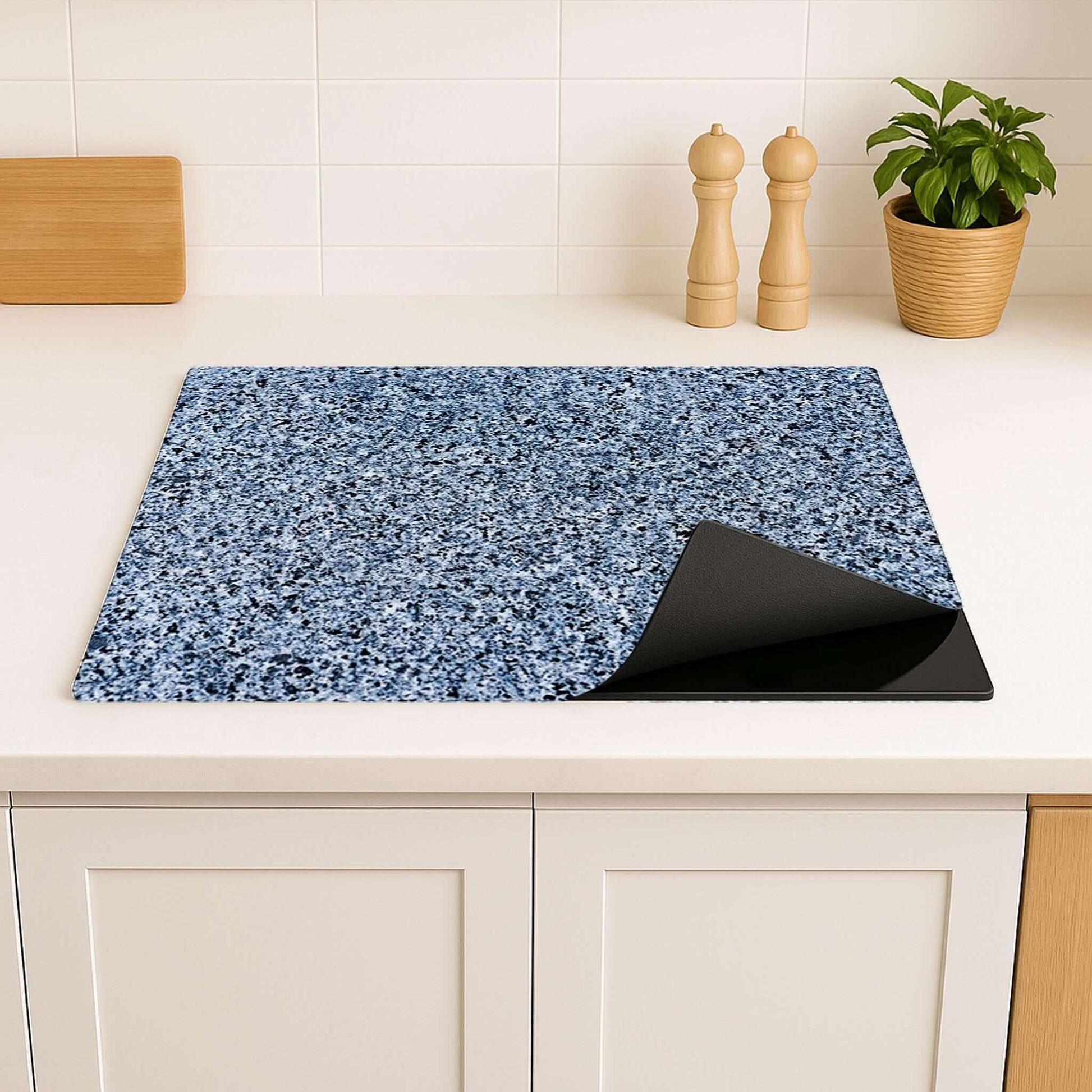 Bovenaanzicht van Baltic Granite inductiebeschermer op inductiekookplaat met blauwe granietprint