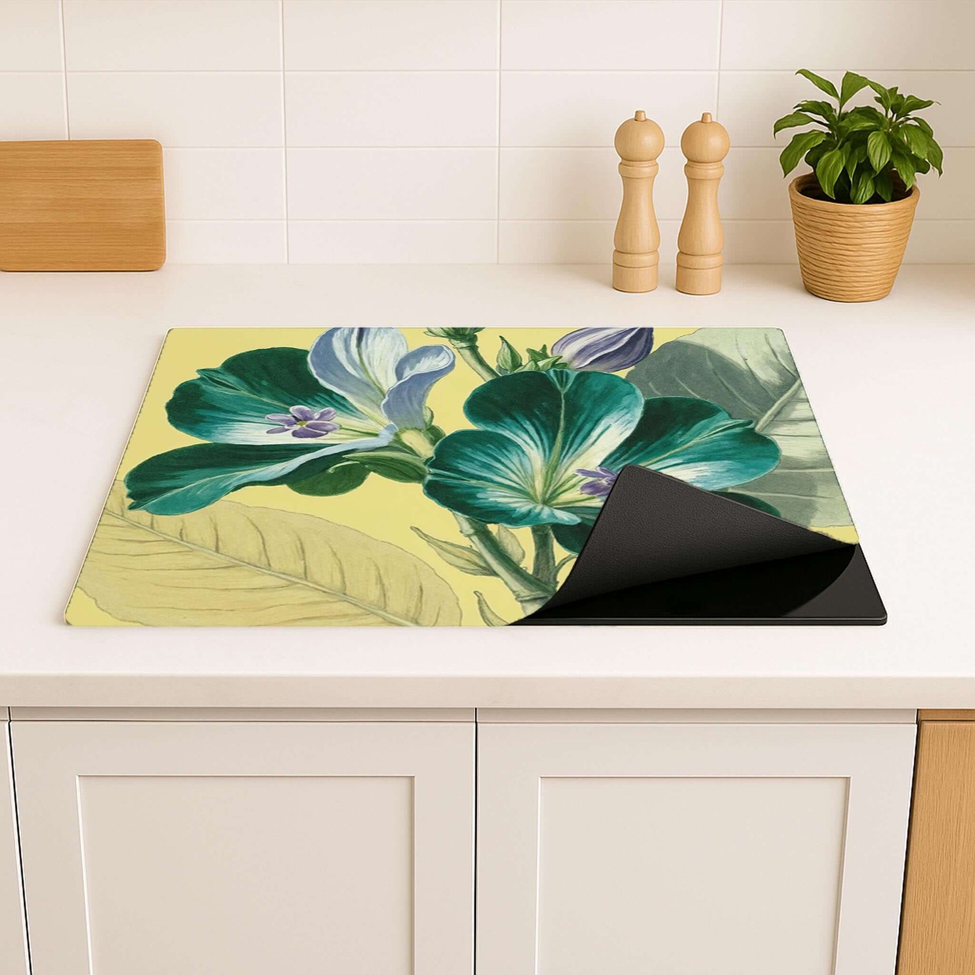 Flexibele inductiebeschermer met groene bloemen in moderne keukenomgeving
