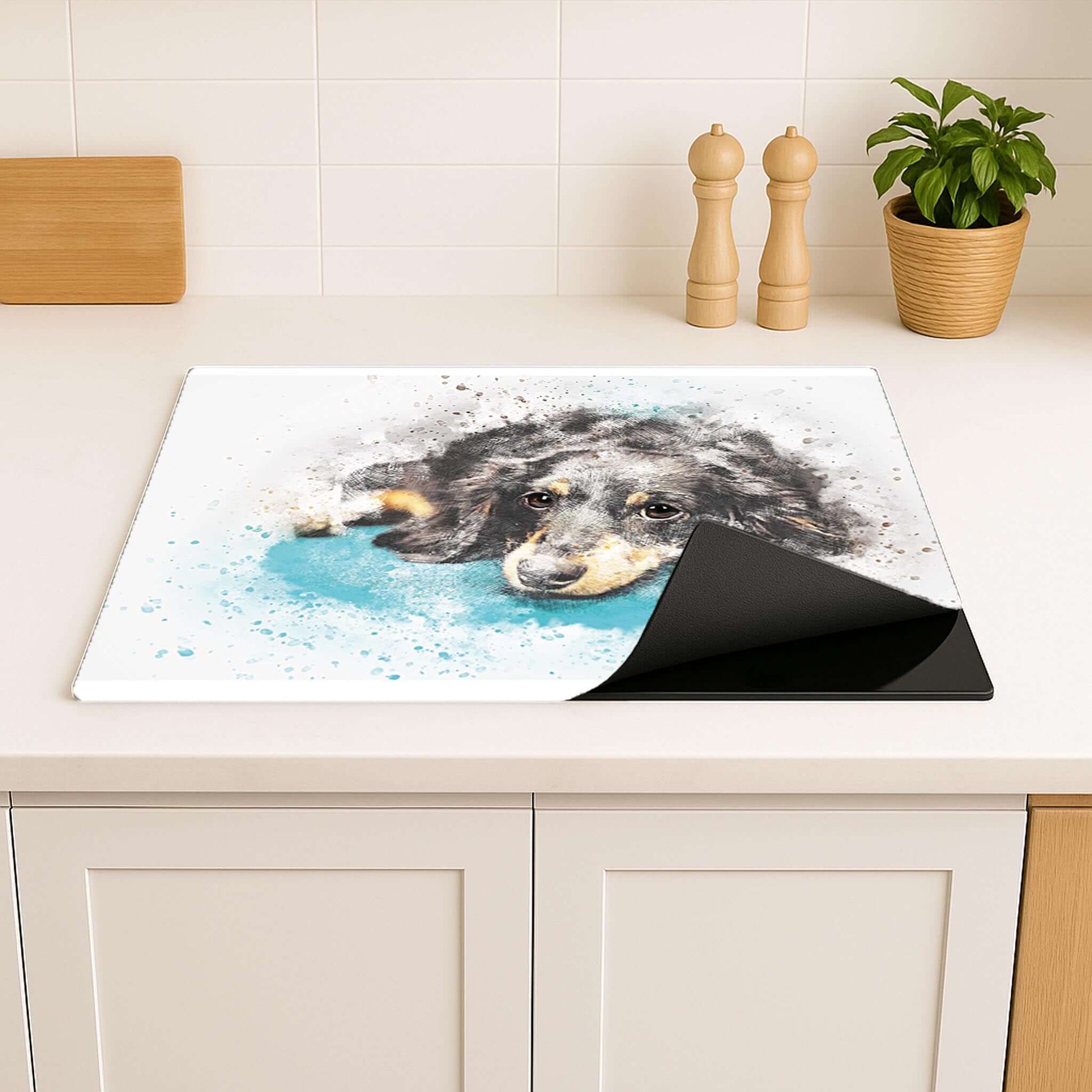 Inductiebeschermer met aquarel teckel, opgerold op een aanrechtblad