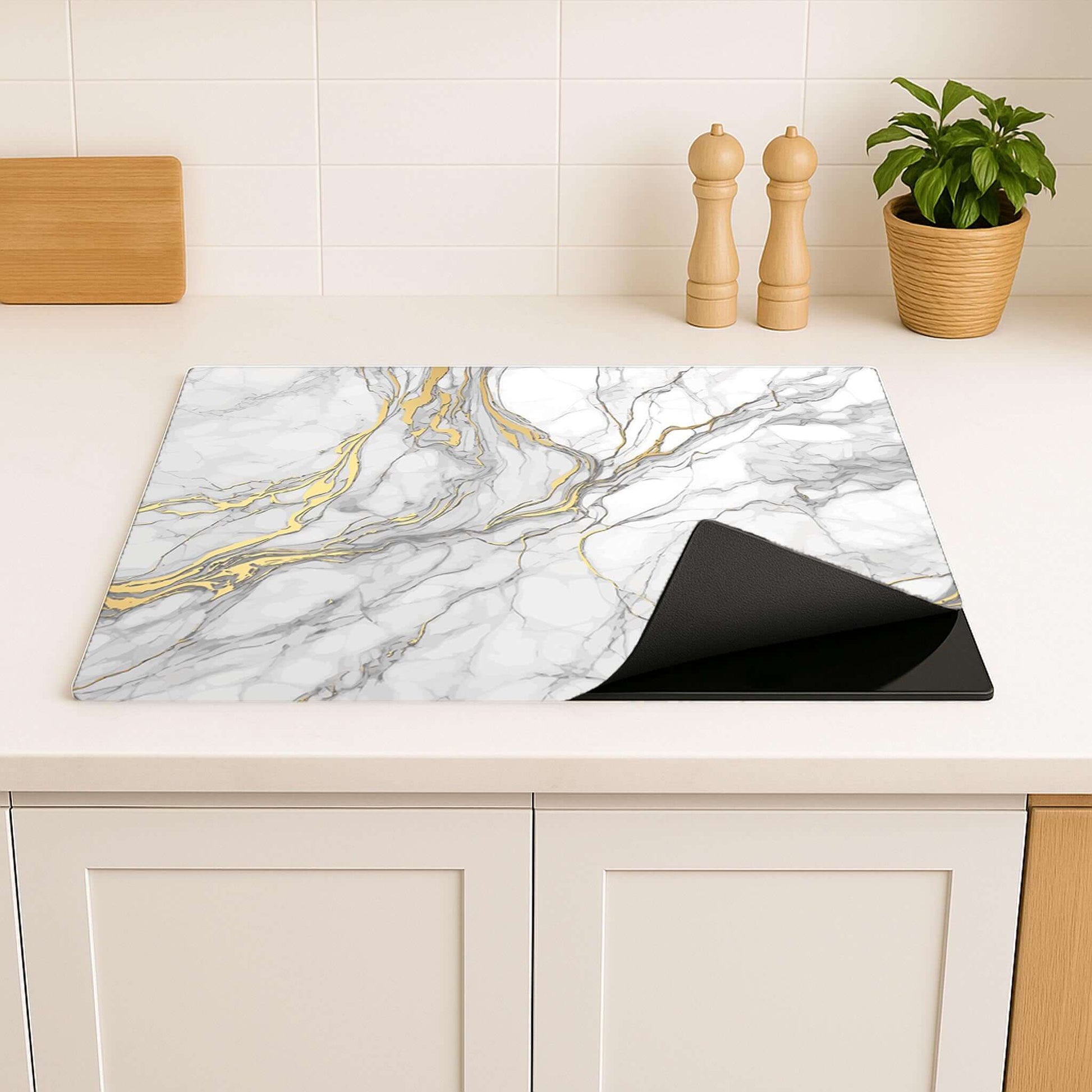 Detail van de Elegant Gold Marble inductie beschermer in een lichte, moderne keuken