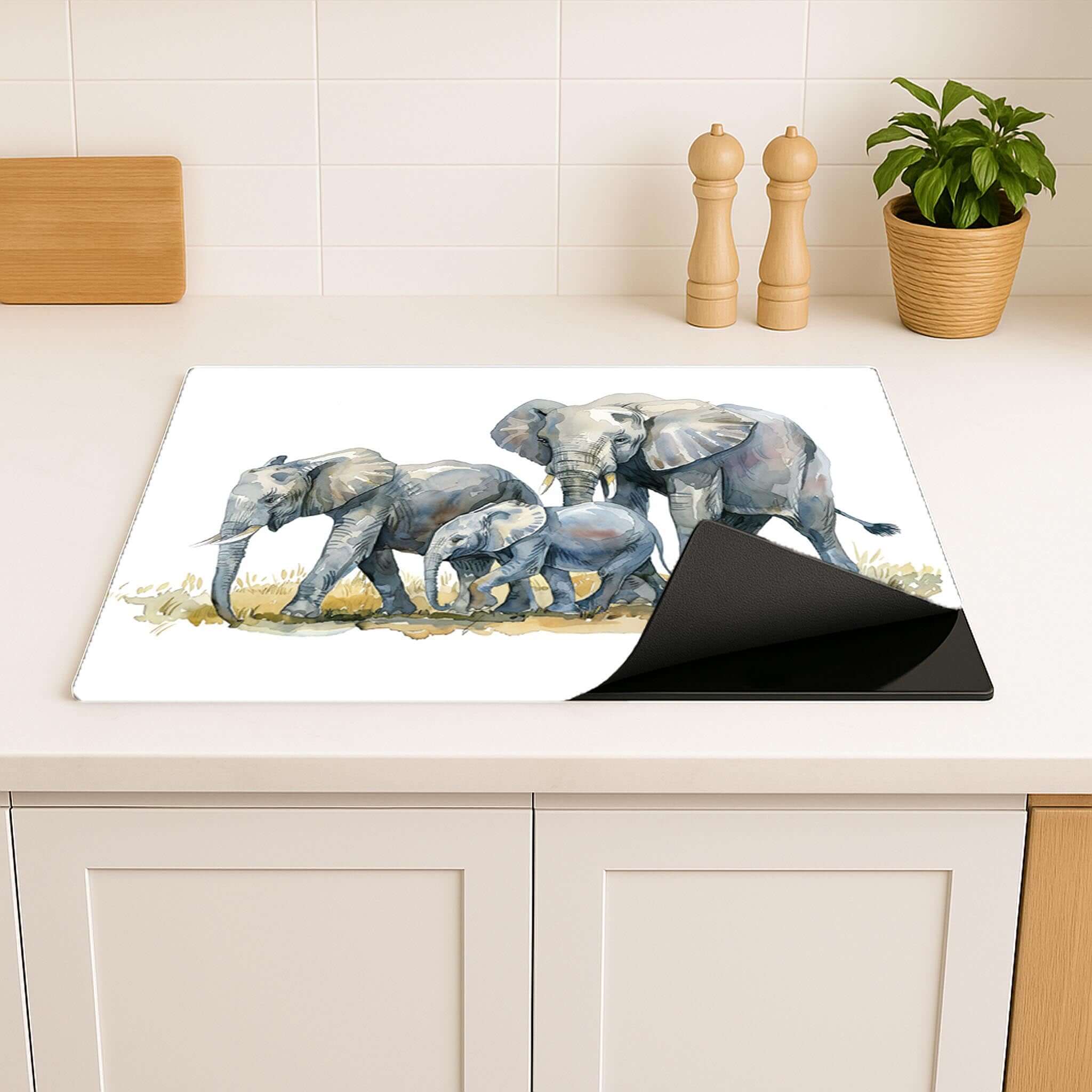 Inductiebeschermer met olifantenfamilie print op aanrecht in lichte keuken.

