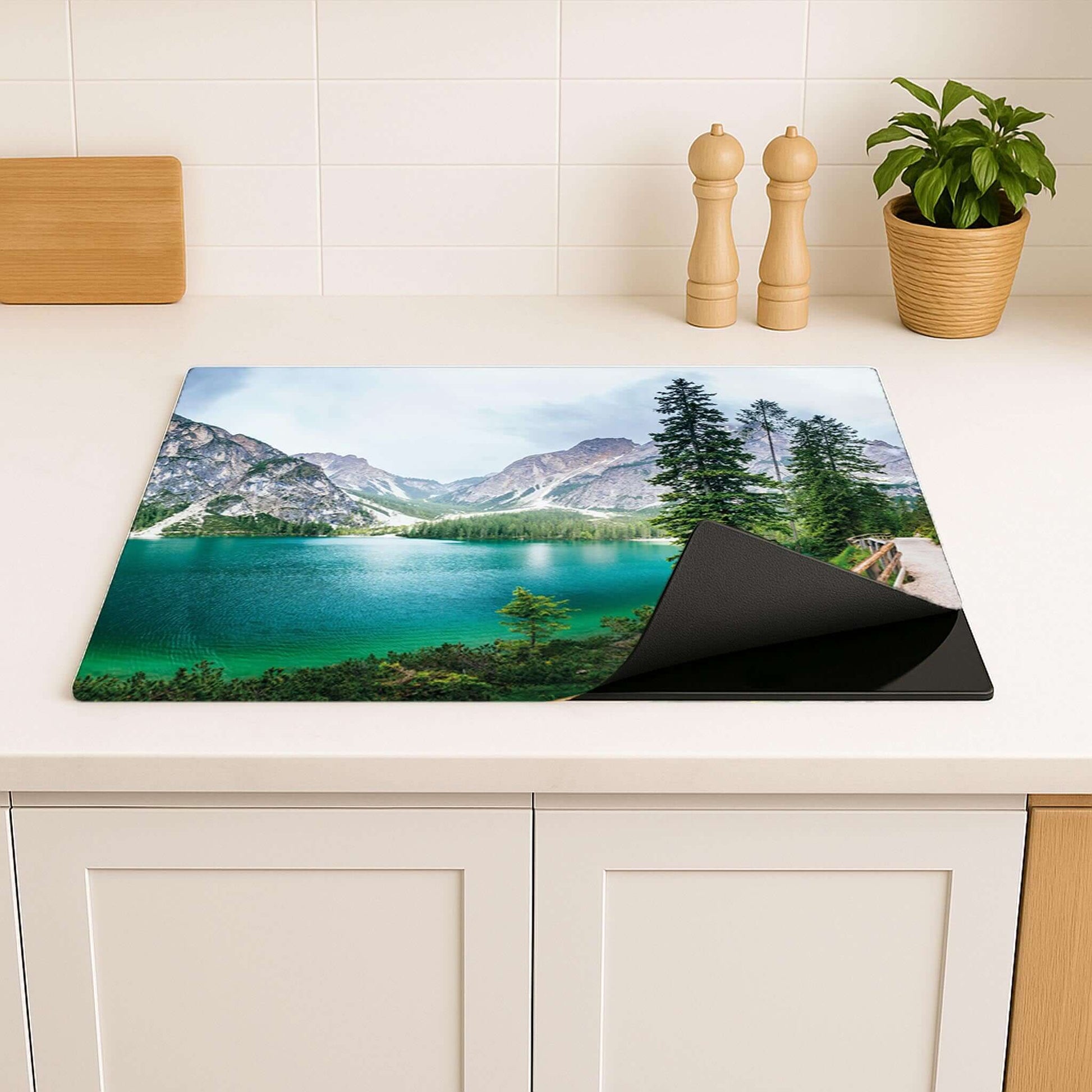 Detail van de inductie beschermer met serene groene kleuren en berglandschap.