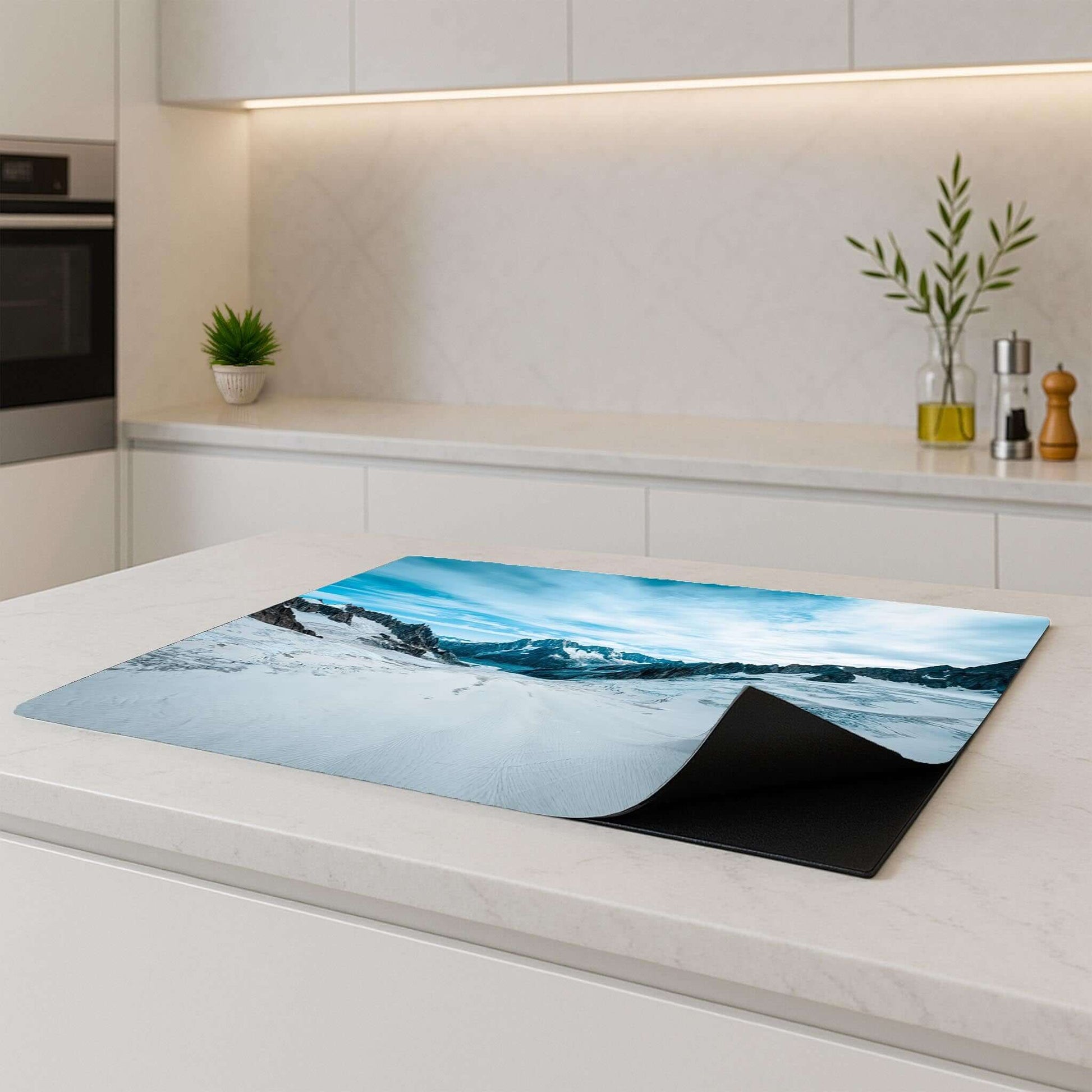 Frozen Peaks inductiebeschermer liggend op een kookplaat in een strakke keuken
