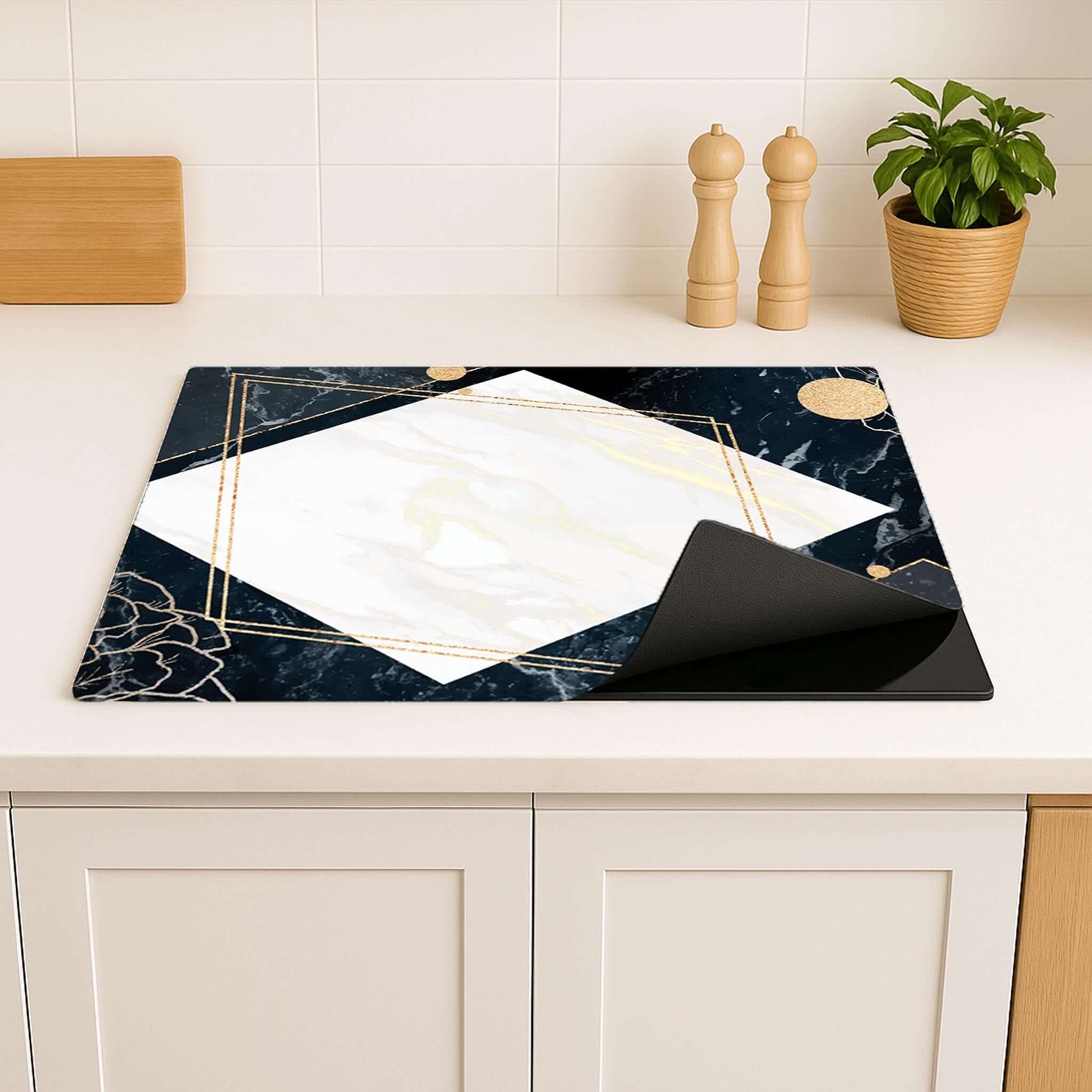 Glamour Marble inductie beschermer, deels opgerold, toont stijlvolle uitstraling op het aanrecht.