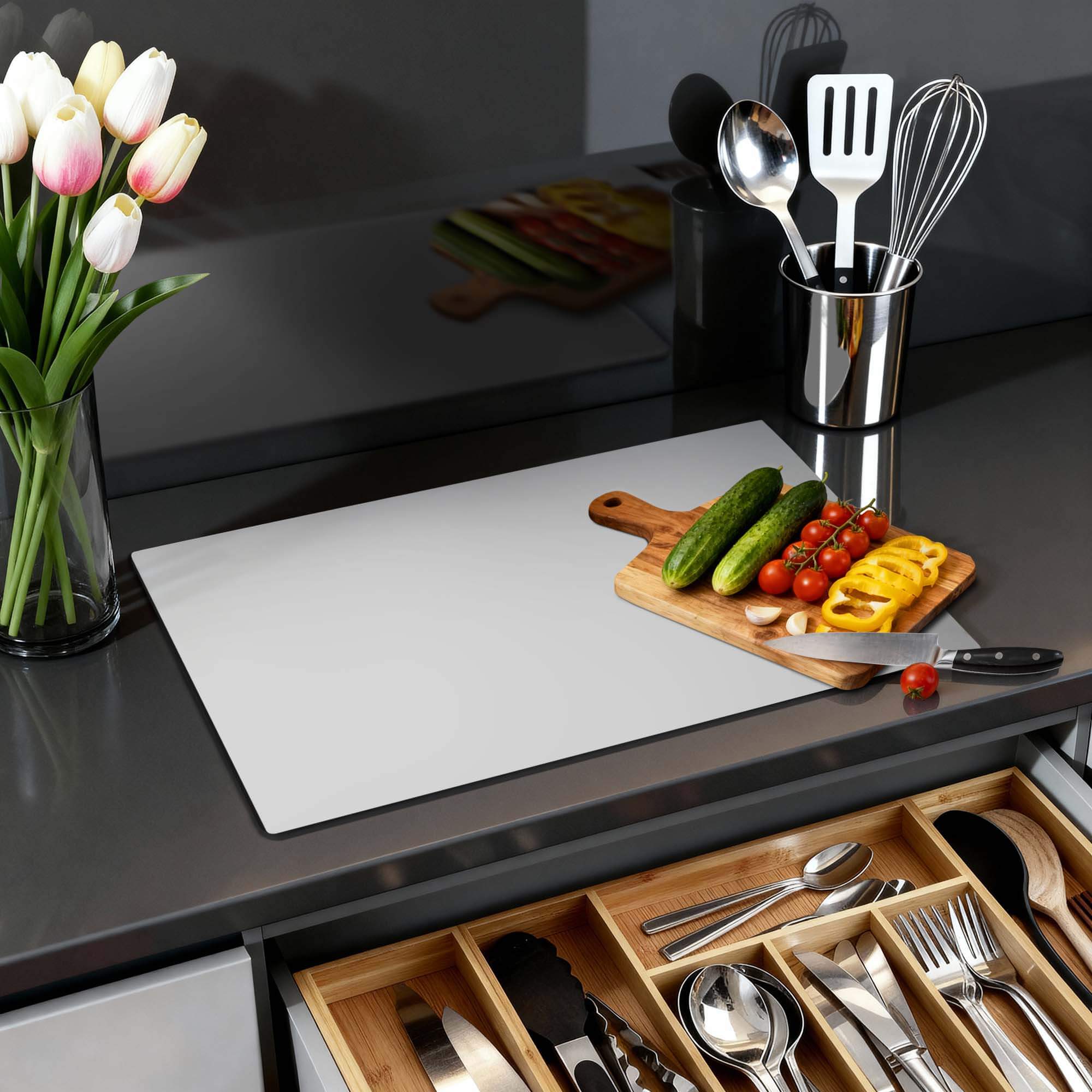 Warm Grey Elegance – Inductie Beschermer op een keukentafel met groenten en bloemen.