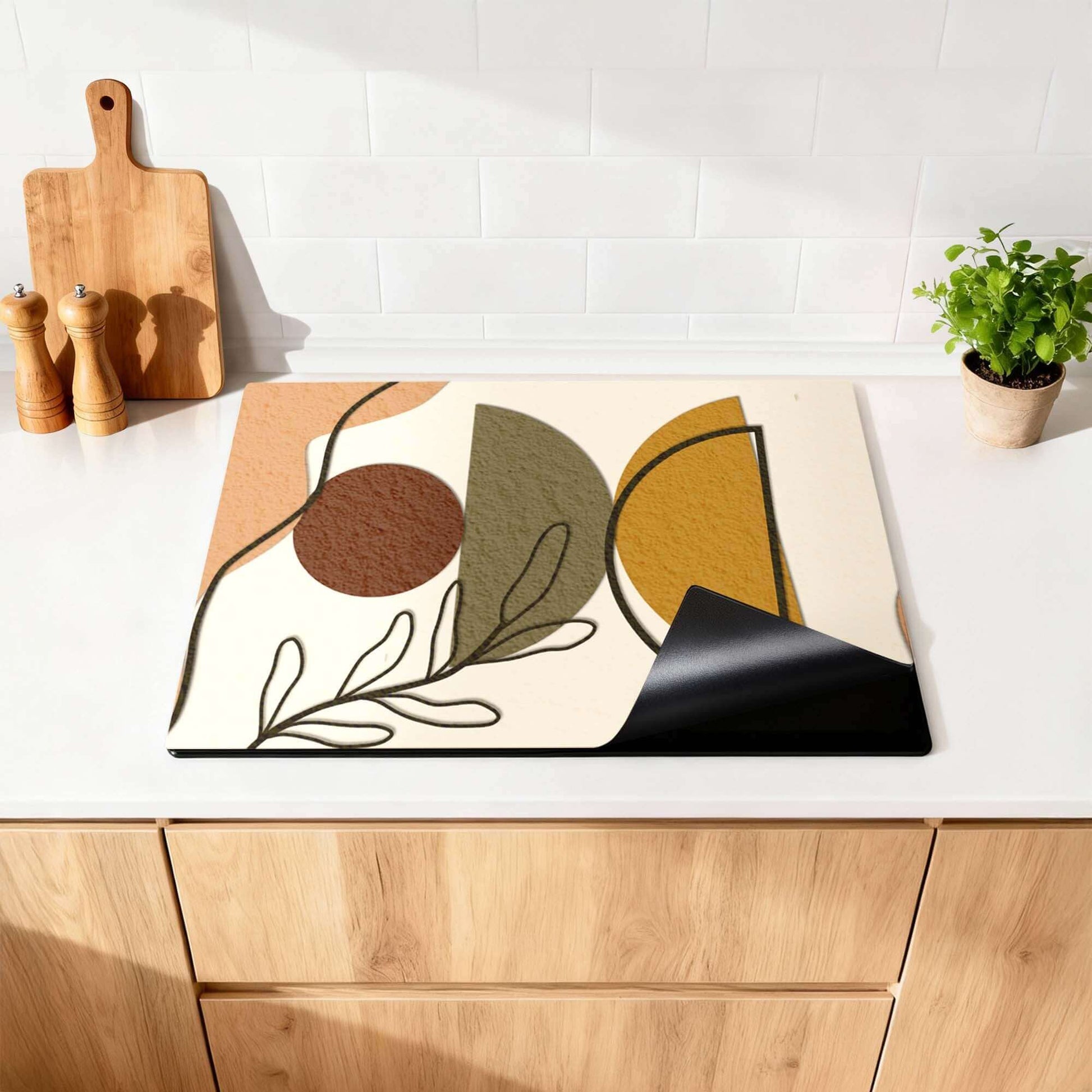 Earth Shapes - Japandi Induction Protector auf einer Küchenarbeitsplatte mit organischen Formen und warmen Farben.