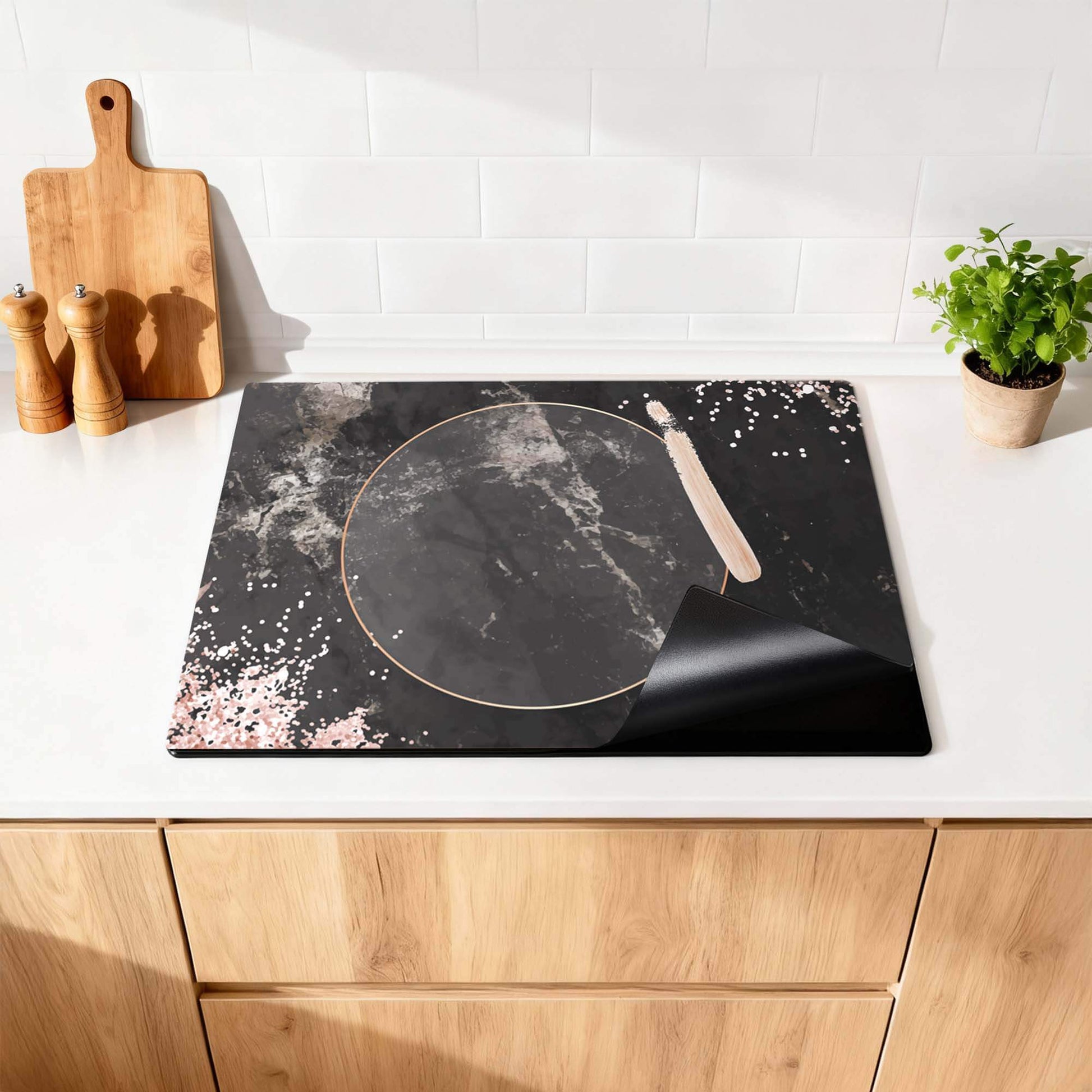Midnight Rose - Inductie Beschermer met zwart marmer en roségouden details op een keukenblad.