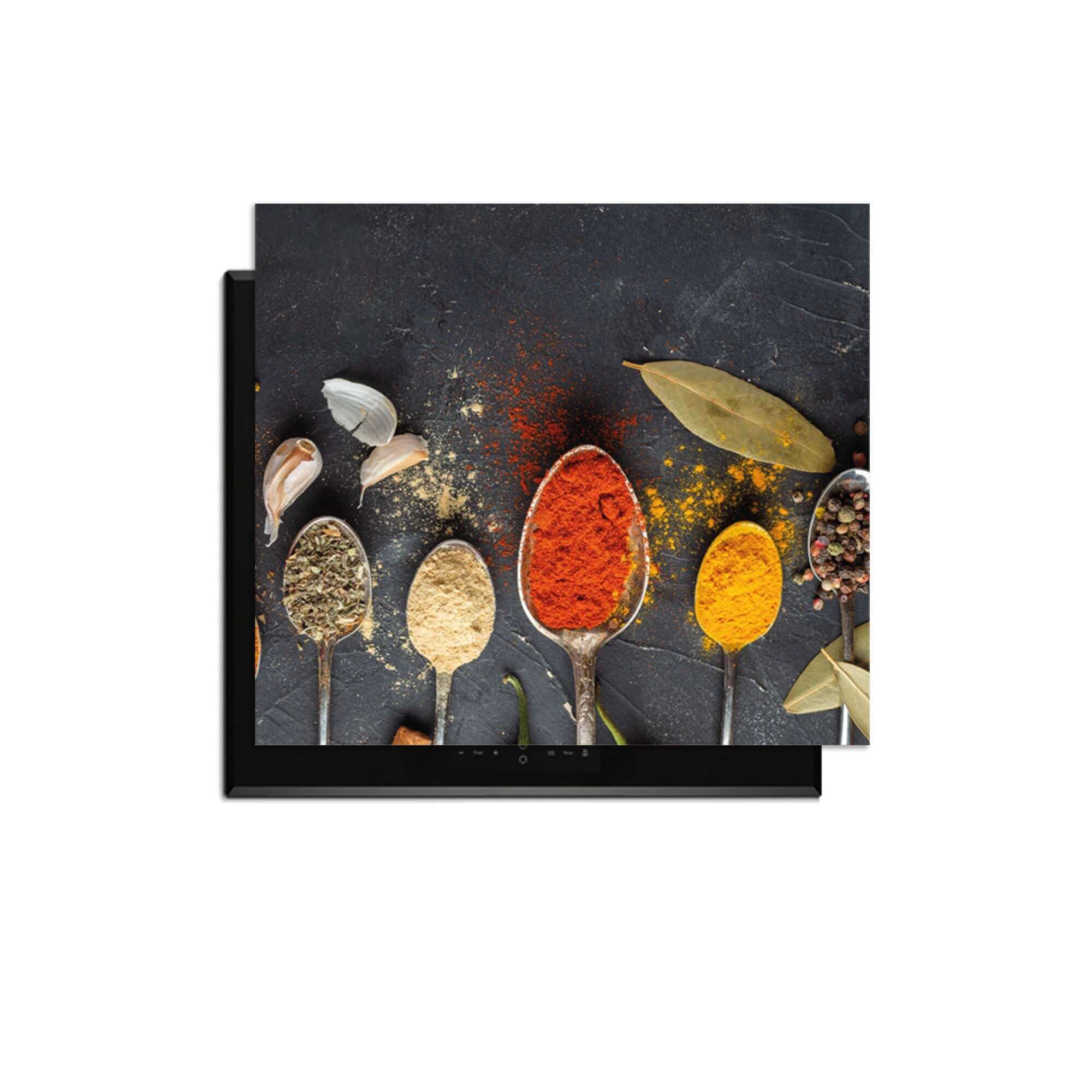Spice Essence - Induction Protector mit eleganten Löffeln voller aromatischer Kräuter und Gewürze auf dunklem Hintergrund.