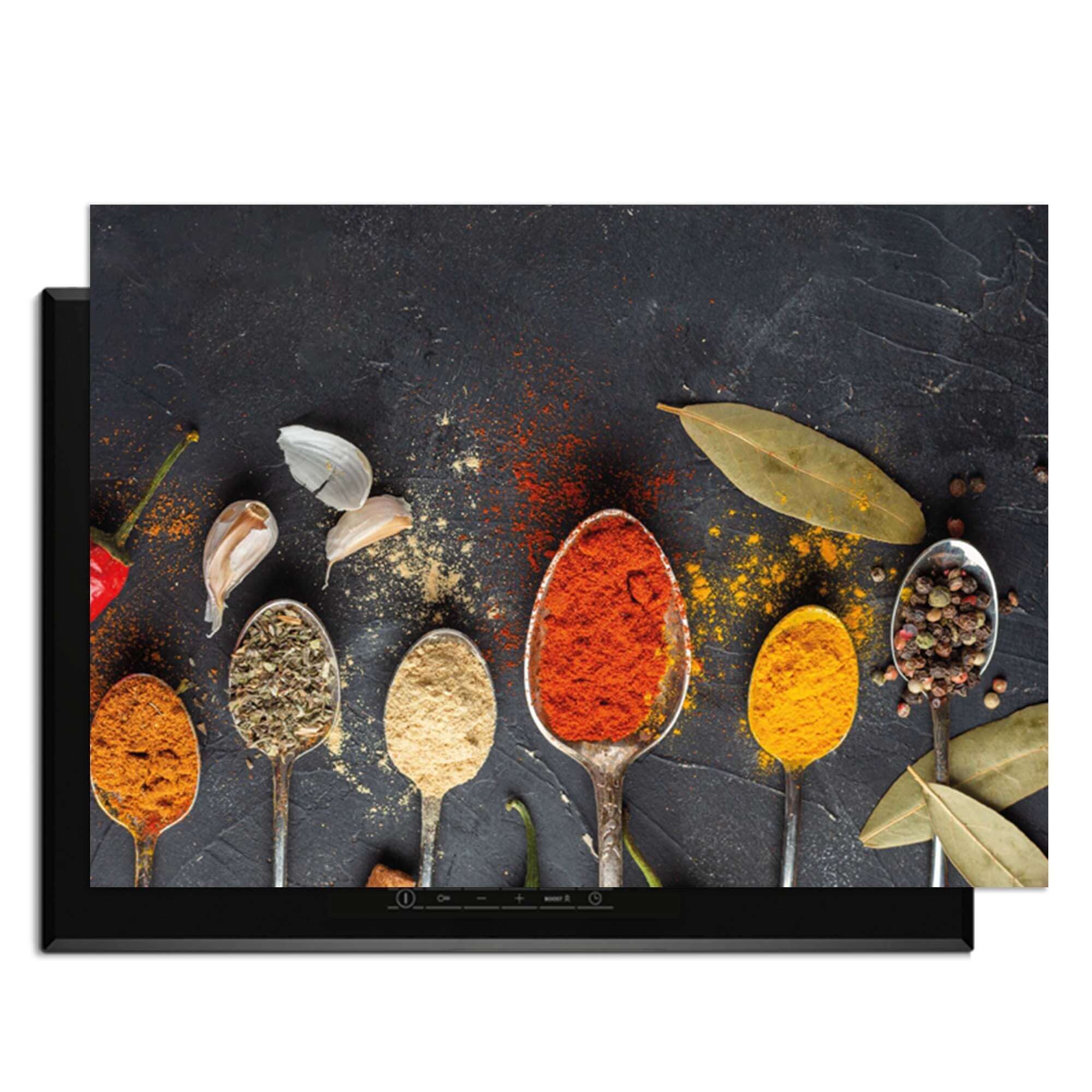 Spice Essence - Induction Protector mit Gewürzlöffeln auf dunklem Hintergrund.