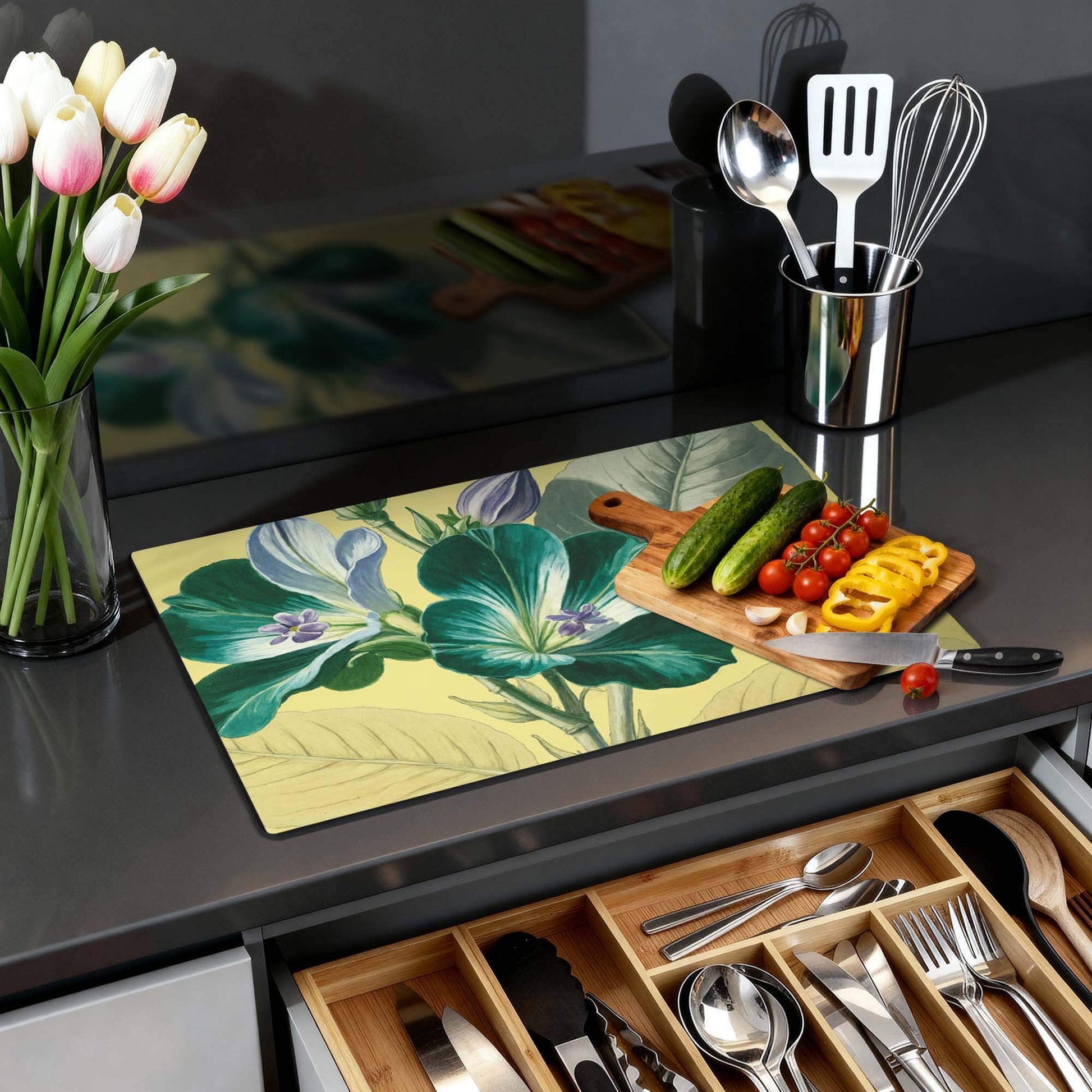 Botanical Glow – Inductie Beschermer met bloemenpatroon op een keukenblad, verse groenten en tulpen in een vaas.