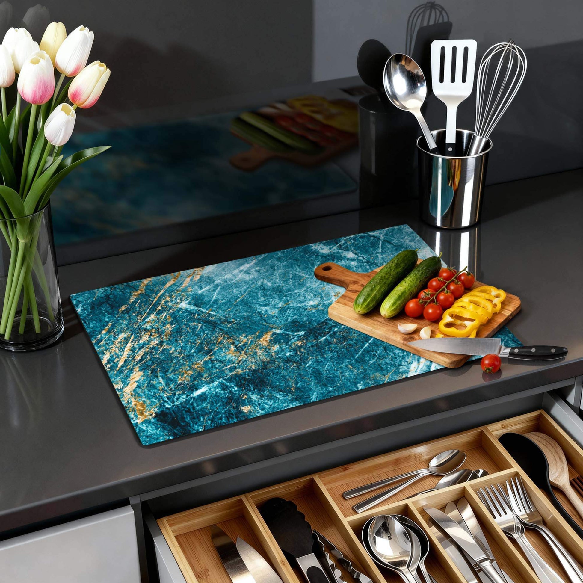 Deep Ocean Marble – Inductie Beschermer op een moderne keukenblad met groenten en bloemen.