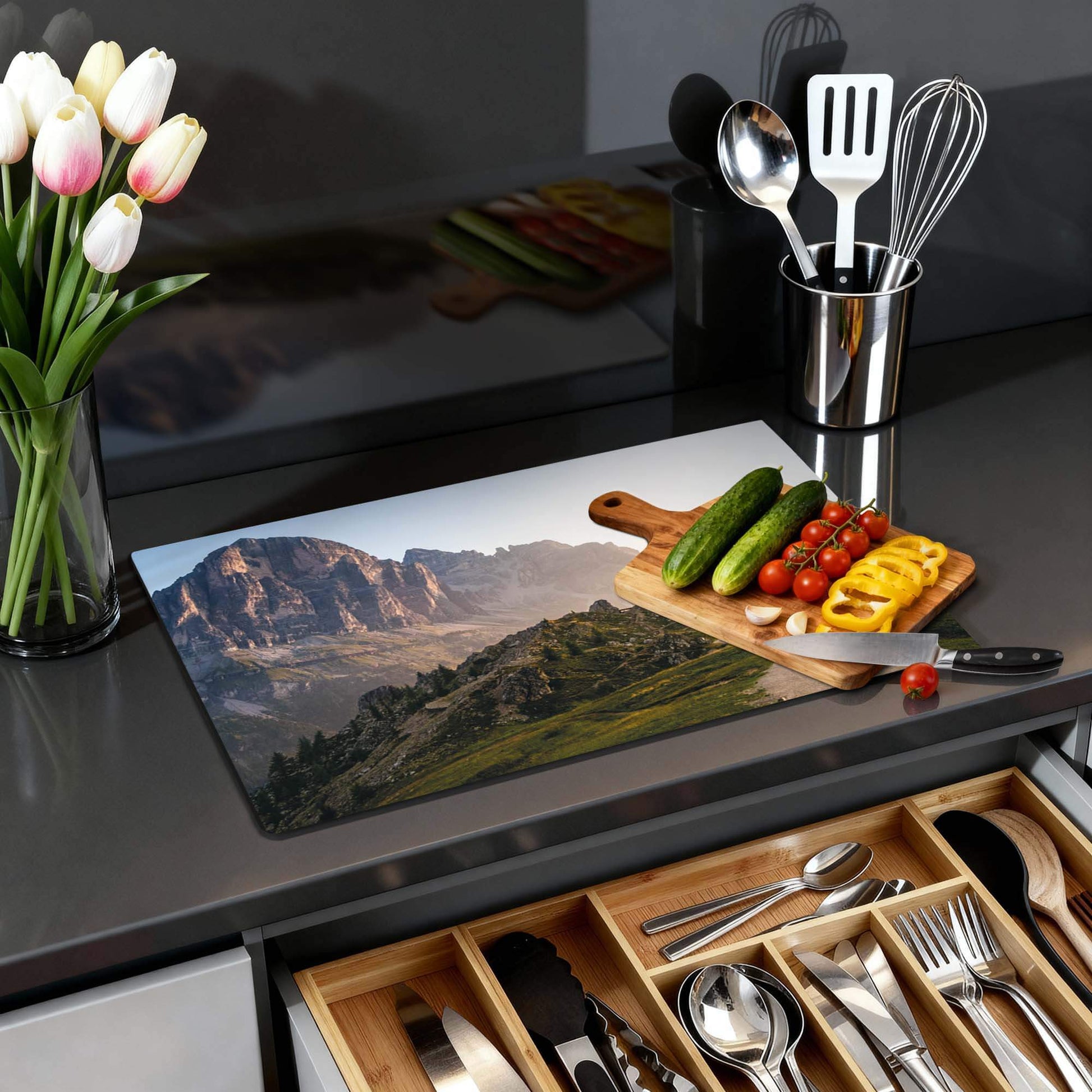 Morning Trails – Inductie Beschermer met een berglandschap en verse groenten op een aanrecht.