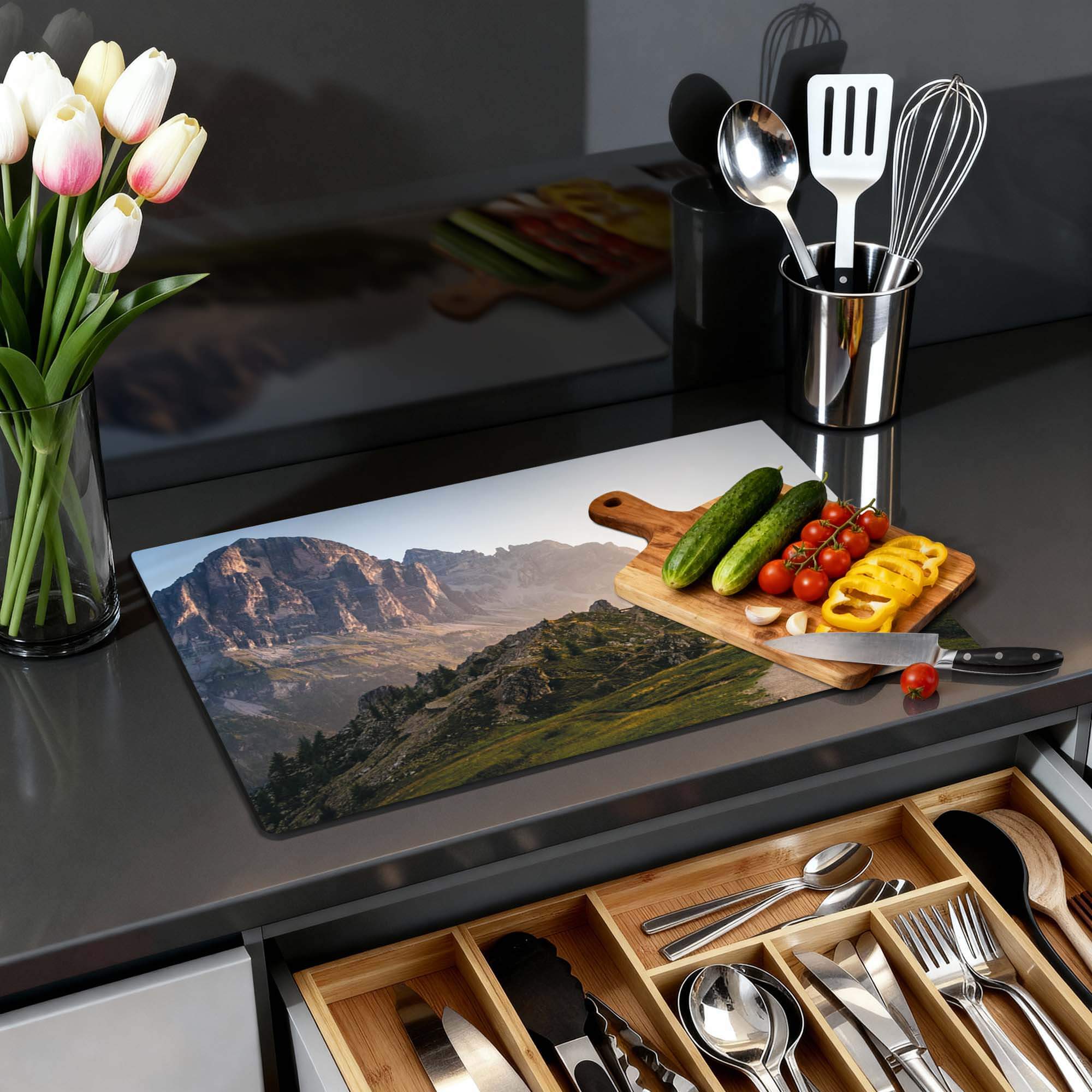 Morning Trails – Inductie Beschermer met een berglandschap en verse groenten op een aanrecht.