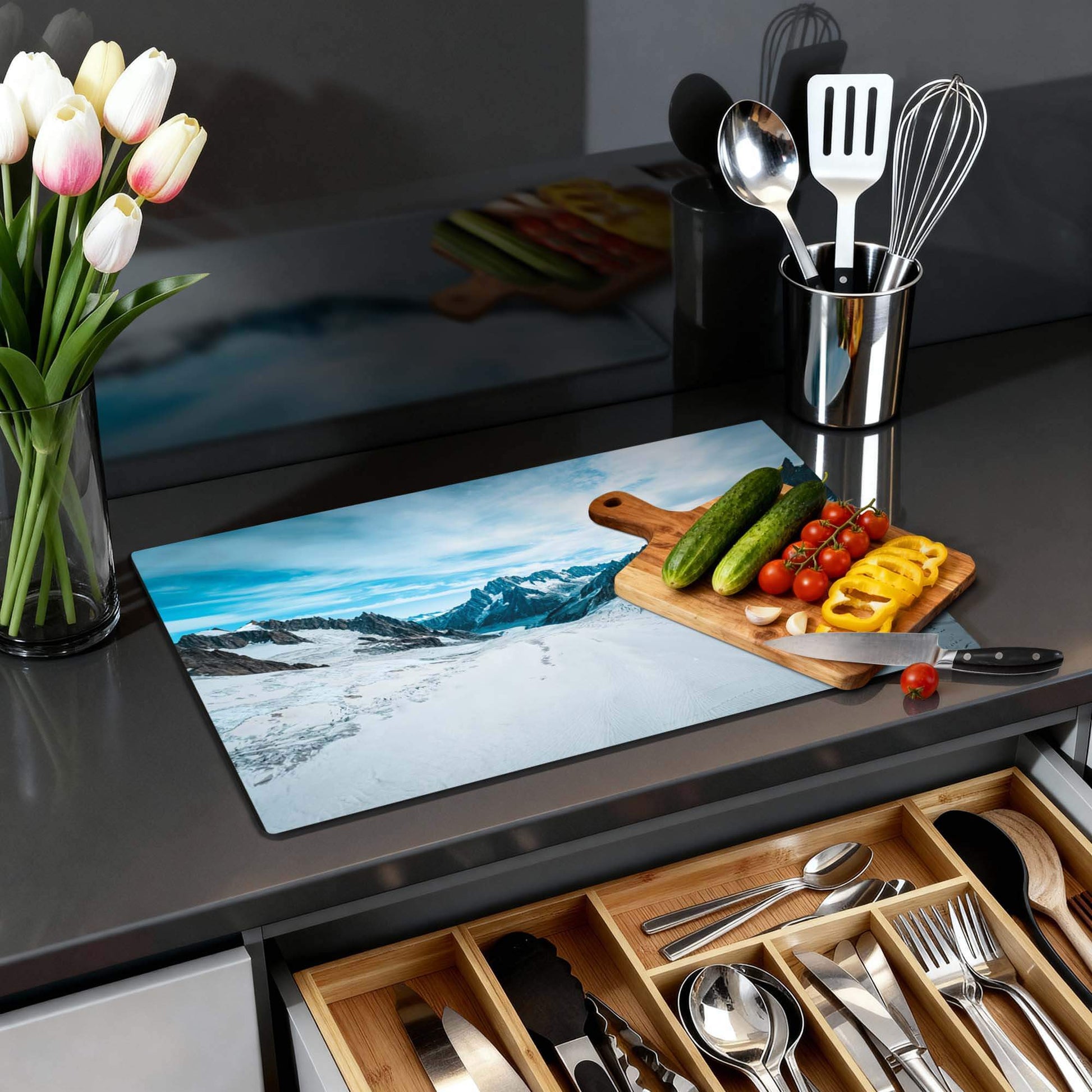 Frozen Peaks - Induction Protector auf einer Küchenplatte mit Gemüse und Blumen.