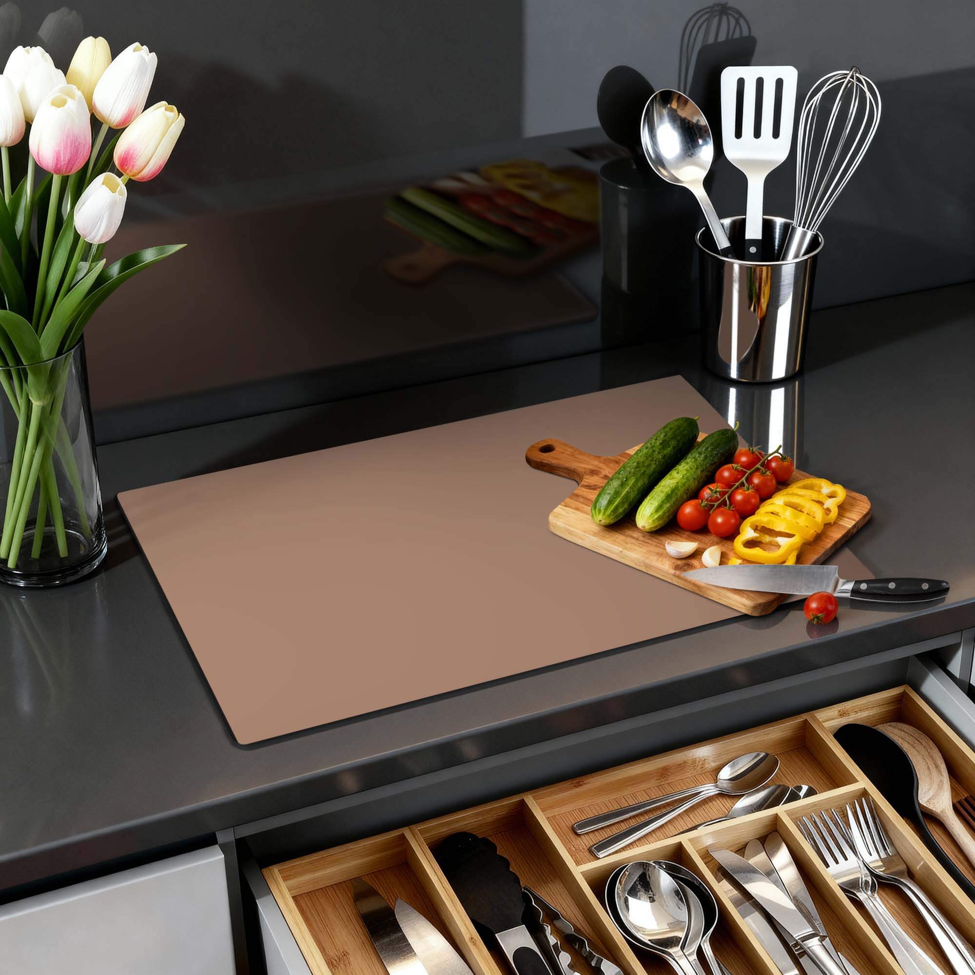 Mocha Mousse – Inductie Beschermer op een keukenblad met groenten en een vaas bloemen.