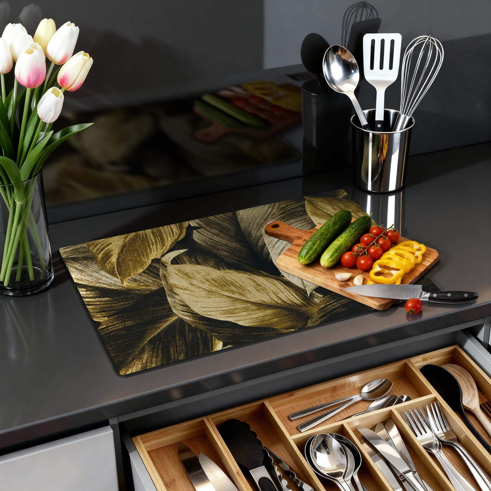 Gouden bladeren design van de Golden Leaves – Inductie Beschermer op een moderne keukenblad met groenten en gereedschap.