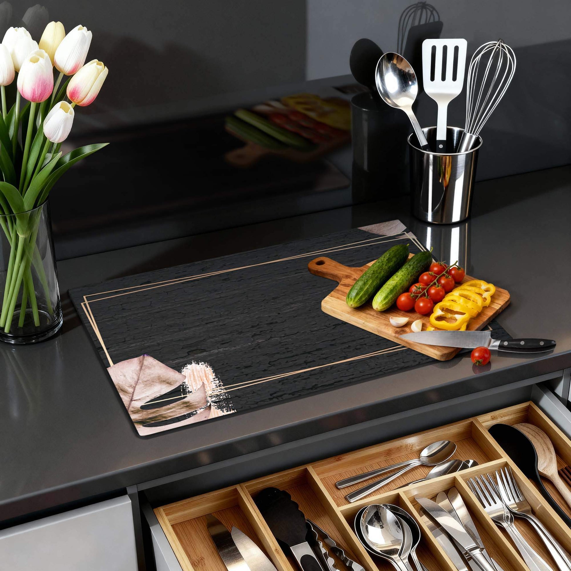 Midnight Leaves - Inductie Beschermer met zwarte achtergrond en beige bladeren op een modern aanrecht.