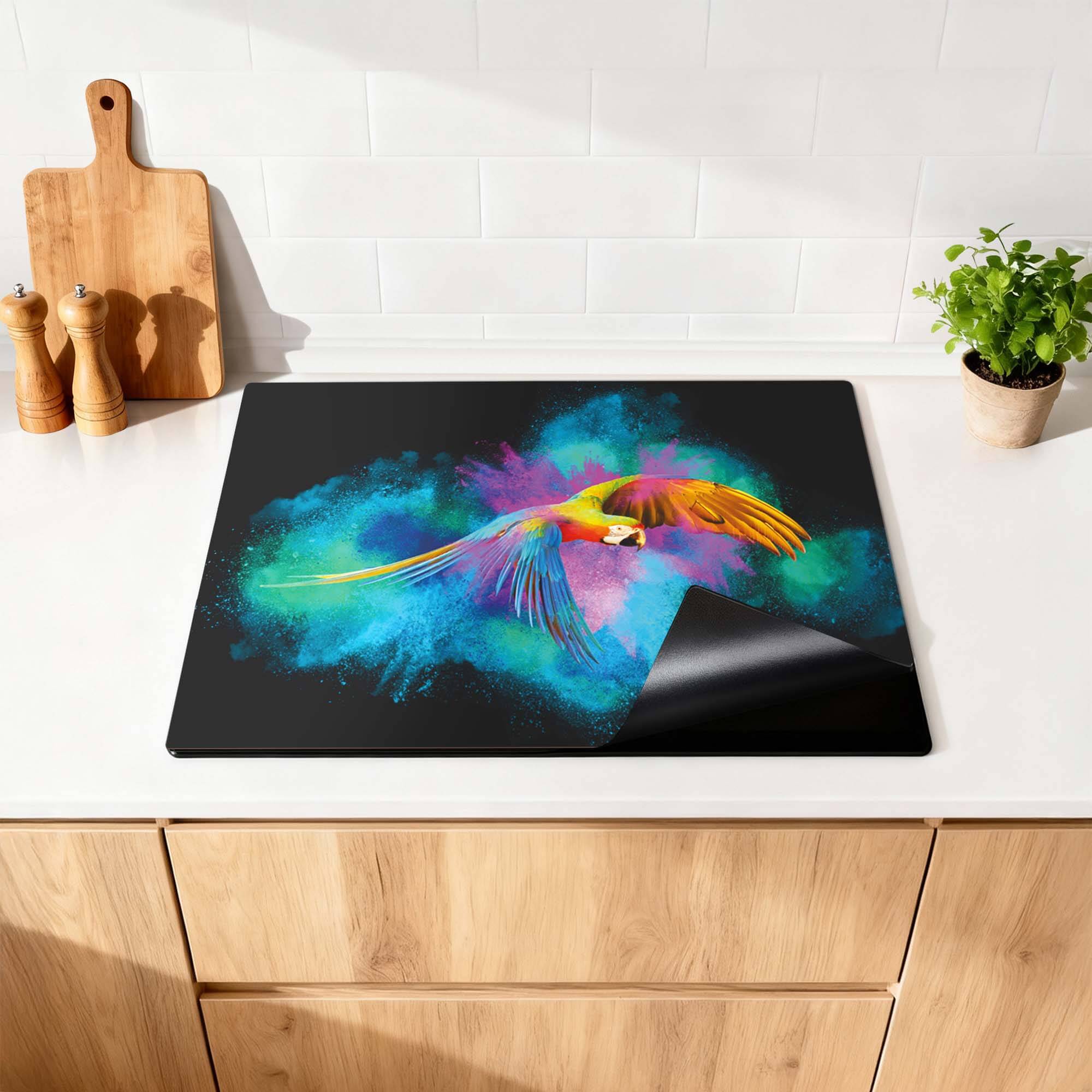 Color Flight – Inductie Beschermer met kleurrijke papegaai en levendige achtergronden in de keuken.