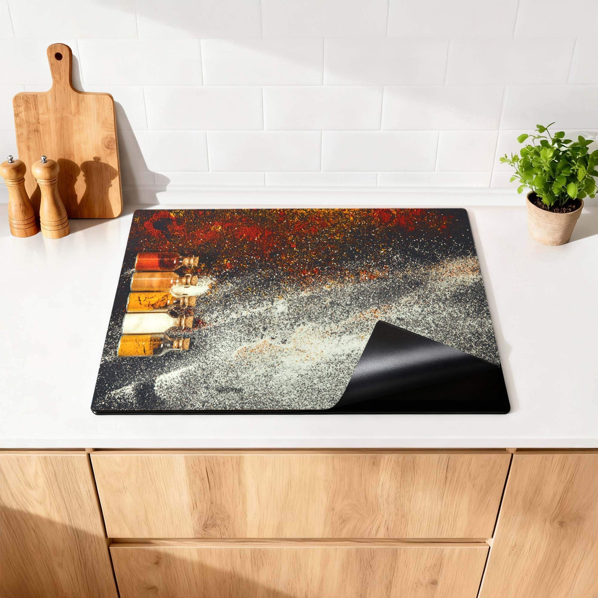 Spice Bottles – Inductie Beschermer op een keukenblad met kruidenflessen en een kleurrijk design.