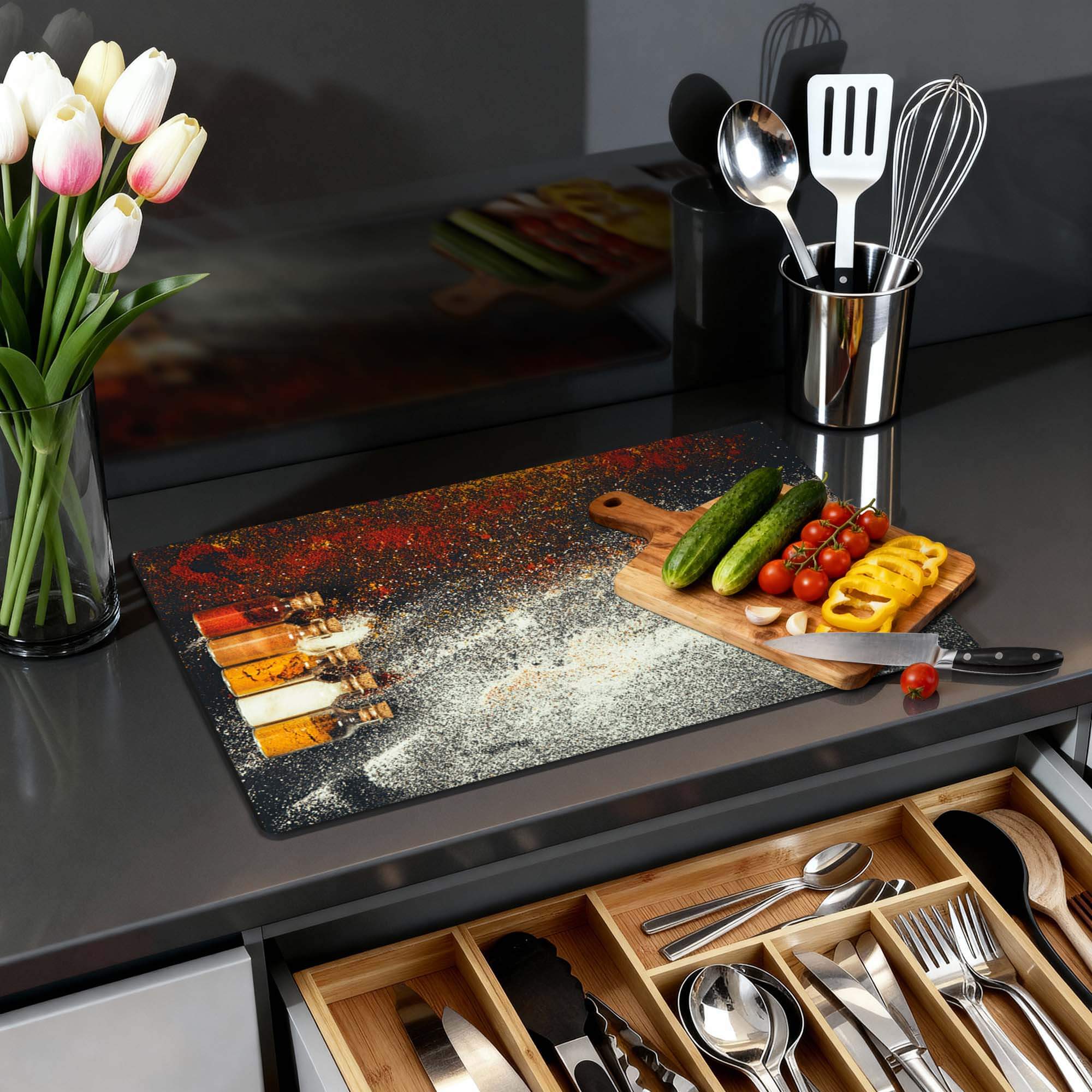 Kleurrijke Spice Bottles – Inductie Beschermer op een moderne keukentafel met verse ingrediënten en tulpen.